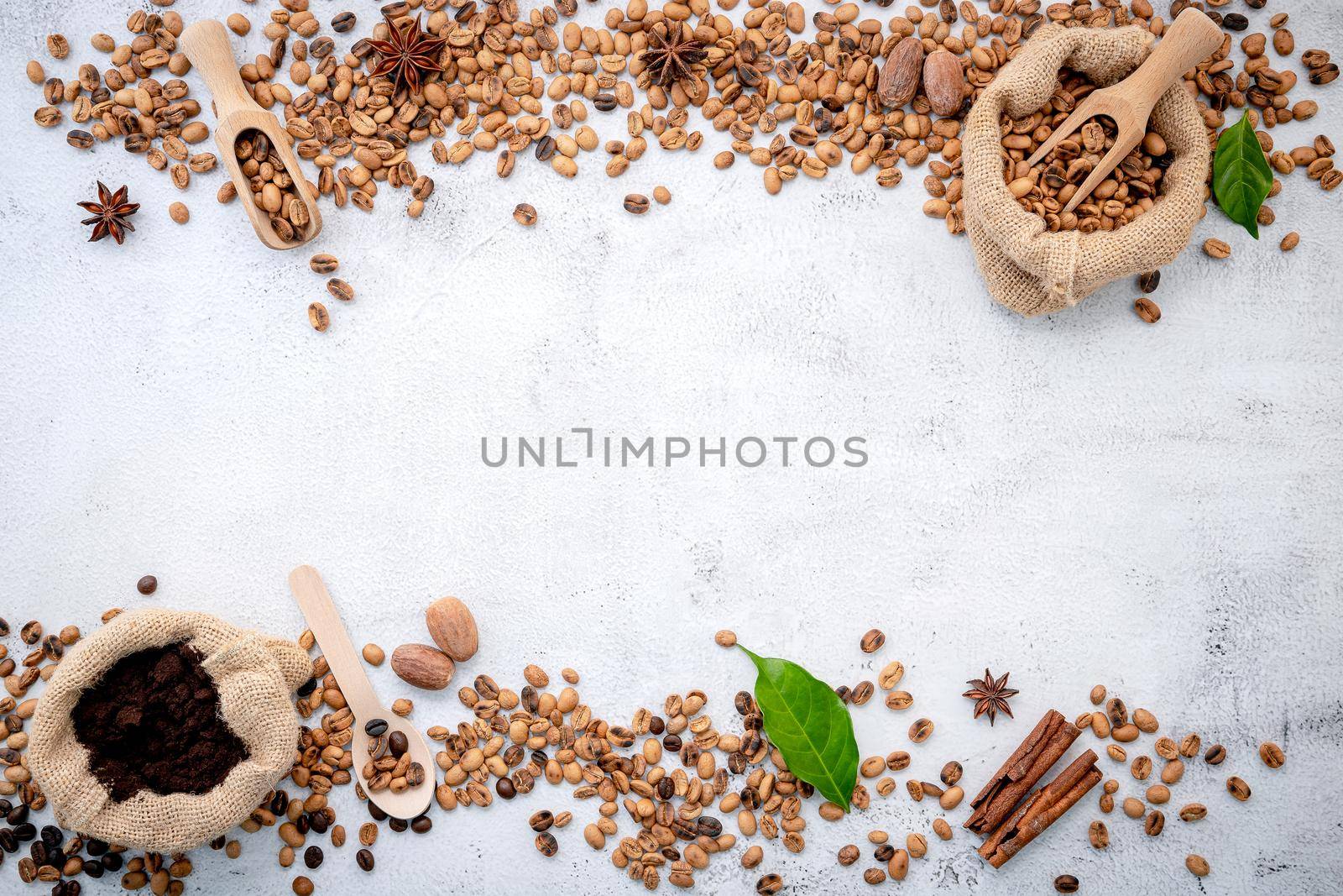 Roasted coffee beans with scoops setup on white concrete background.