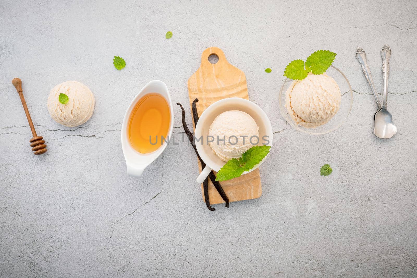 Vanilla ice cream flavor in bowl with vanilla pods setup on concrete background . Summer and Sweet menu concept. by kerdkanno