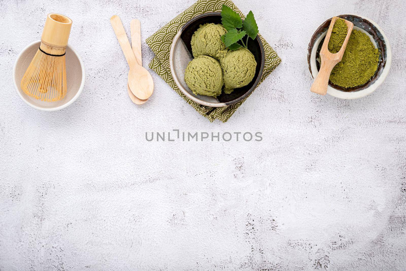 Matcha green tea ice cream with waffle cone and mint leaves  setup on white stone background . Summer and Sweet menu concept. by kerdkanno