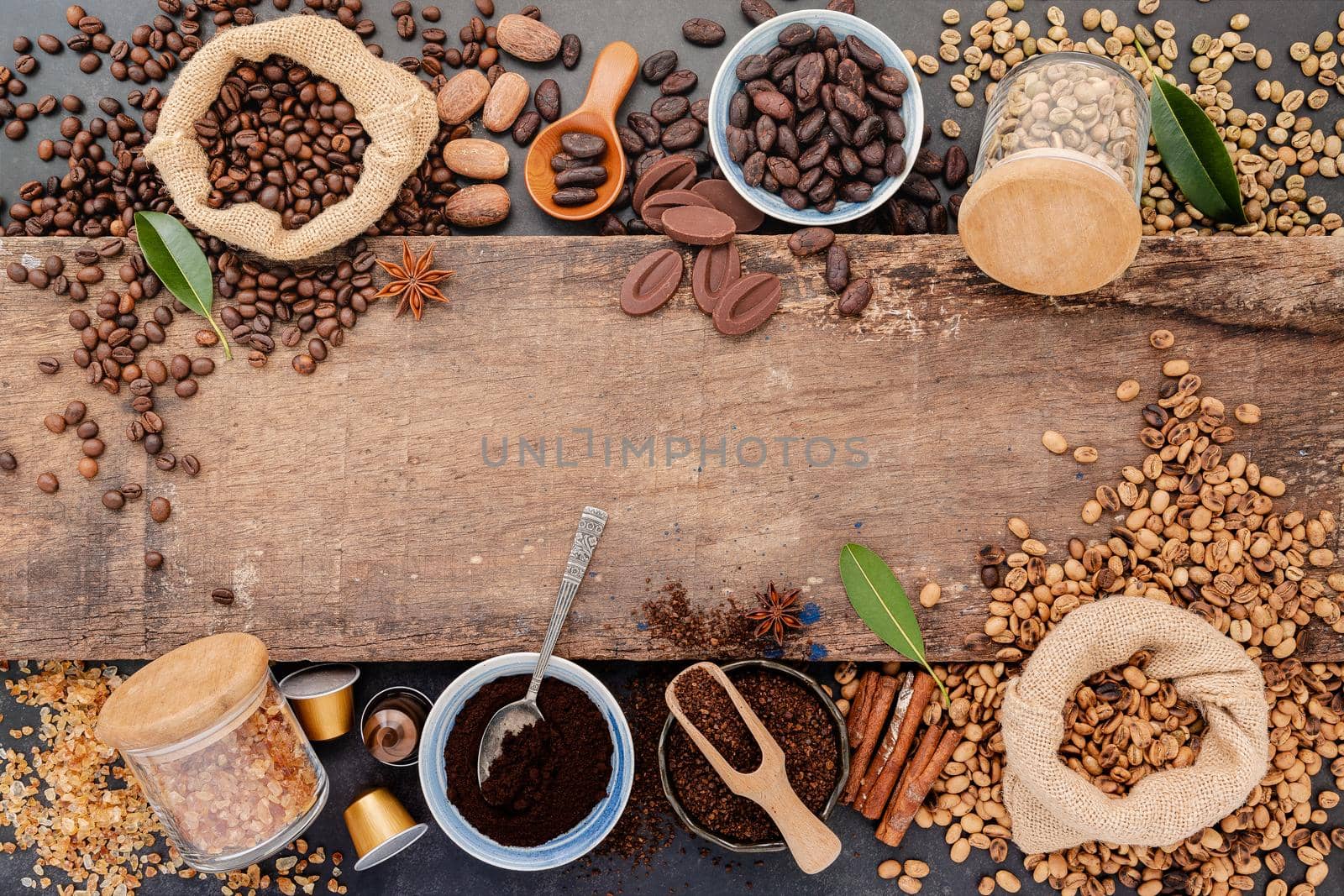 Background of various coffee , dark roasted coffee beans , ground and capsules with scoops setup on wooden background with copy space. by kerdkanno