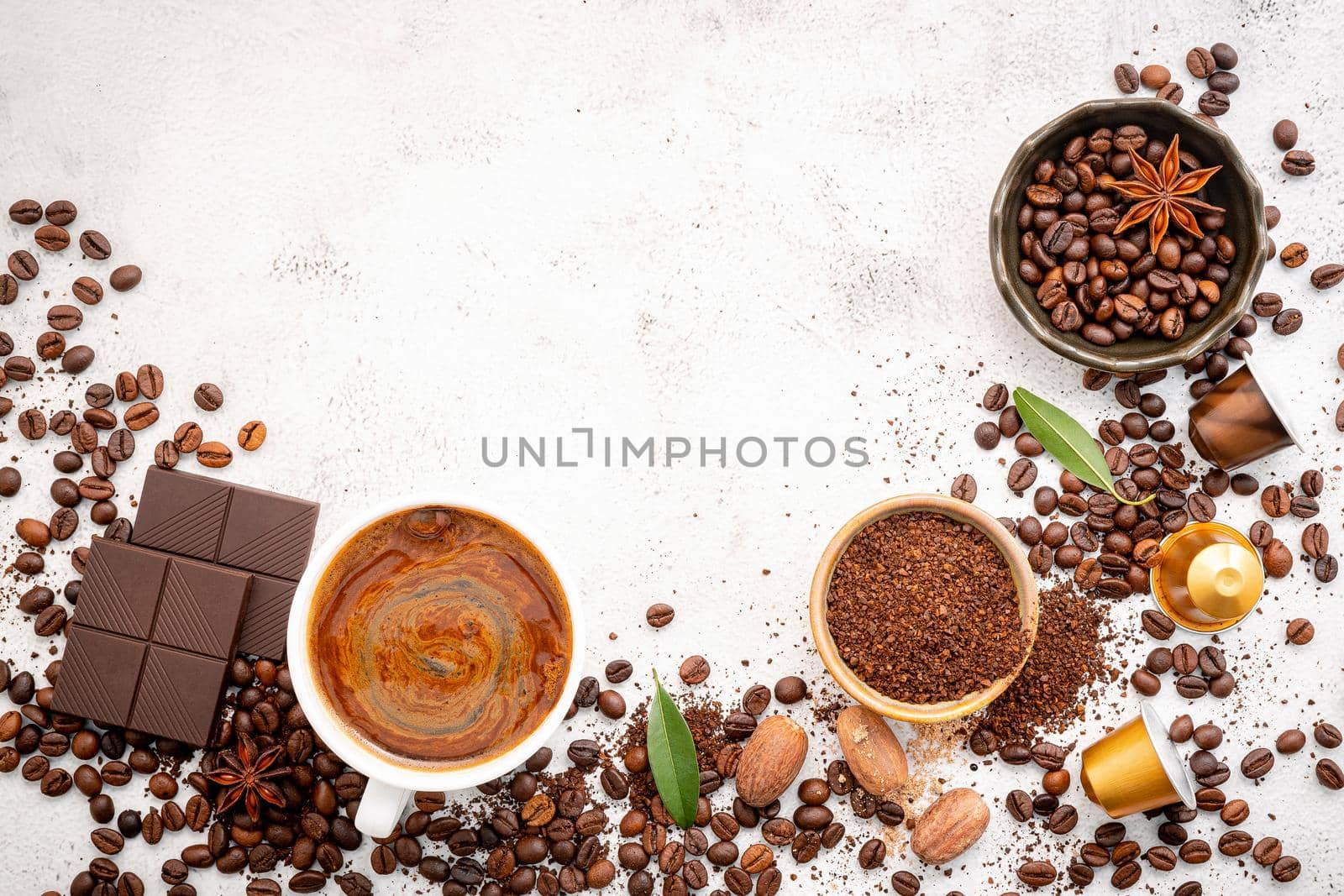 Background of various coffee , dark roasted coffee beans , ground and capsules with scoops setup on white concrete background with copy space.