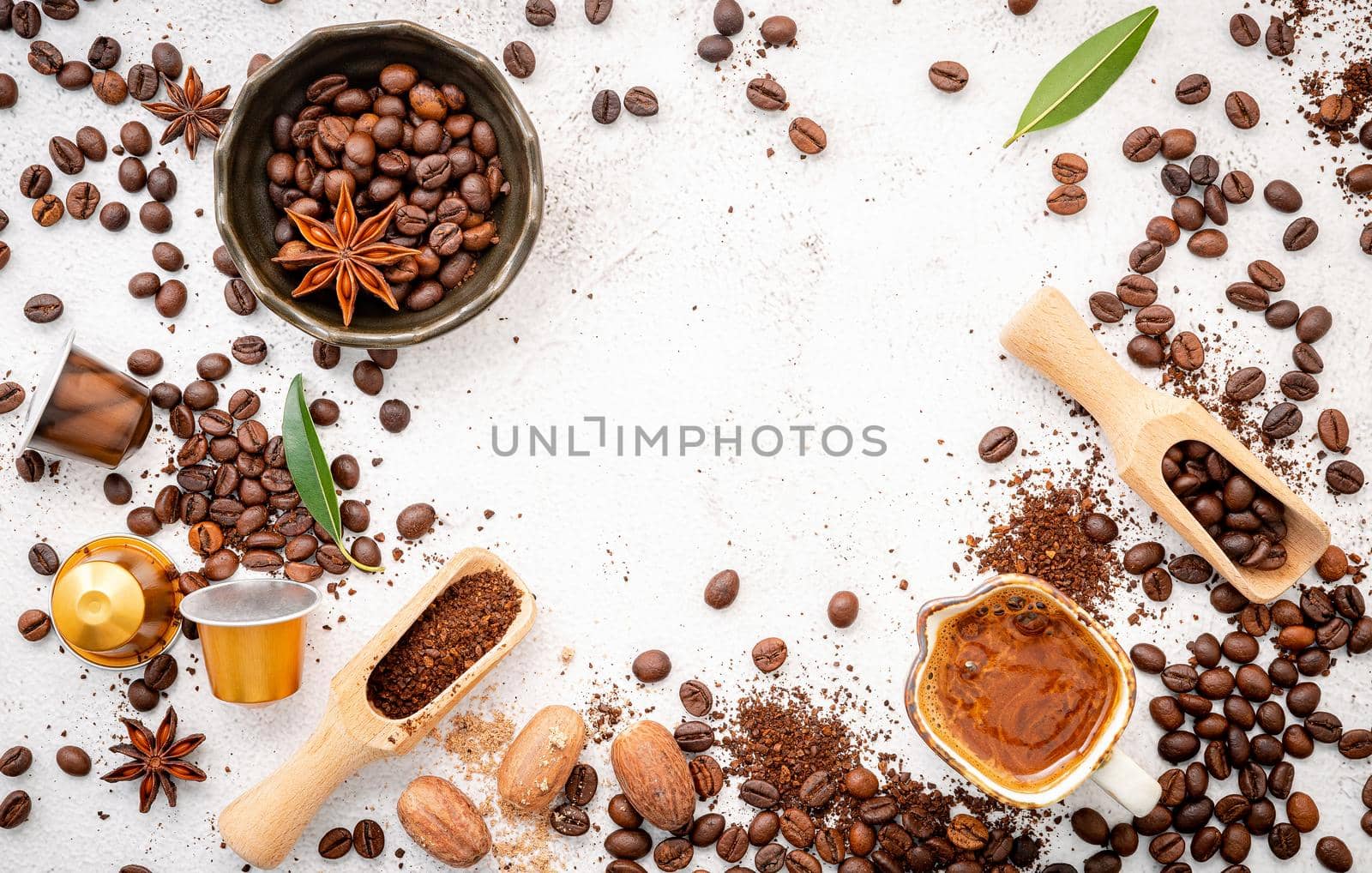 Background of various coffee , dark roasted coffee beans , ground and capsules with scoops setup on white concrete background with copy space.