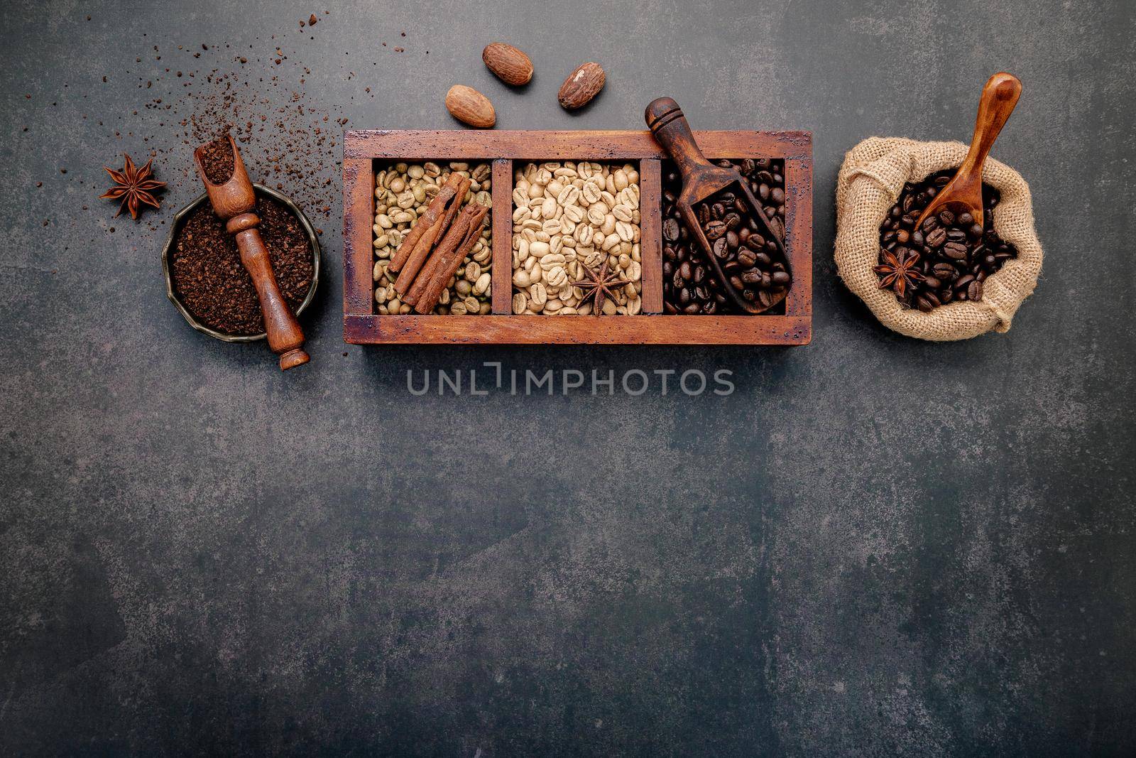  Roasted coffee beans with coffee powder and flavourful ingredients for make tasty coffee setup on dark stone background. by kerdkanno