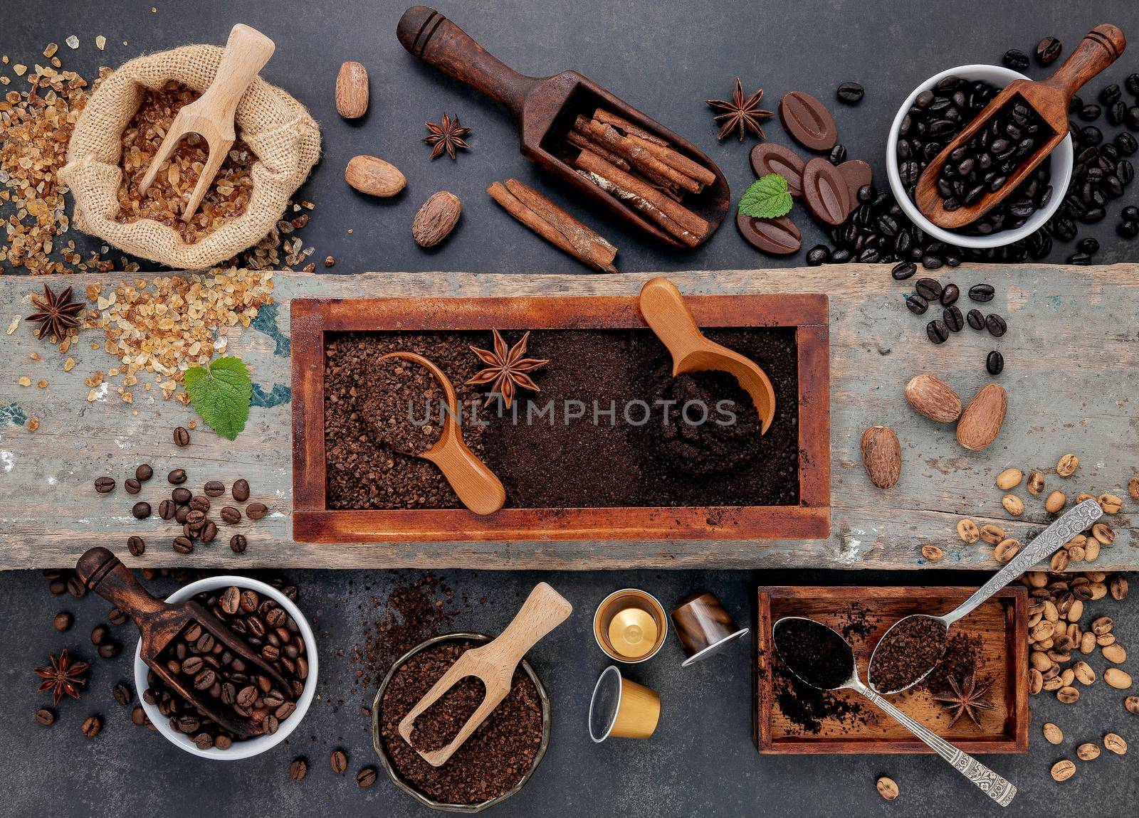 Coffee background with various of roasted coffee beans and flavourful ingredients for make tasty coffee setup on dark stone background. by kerdkanno