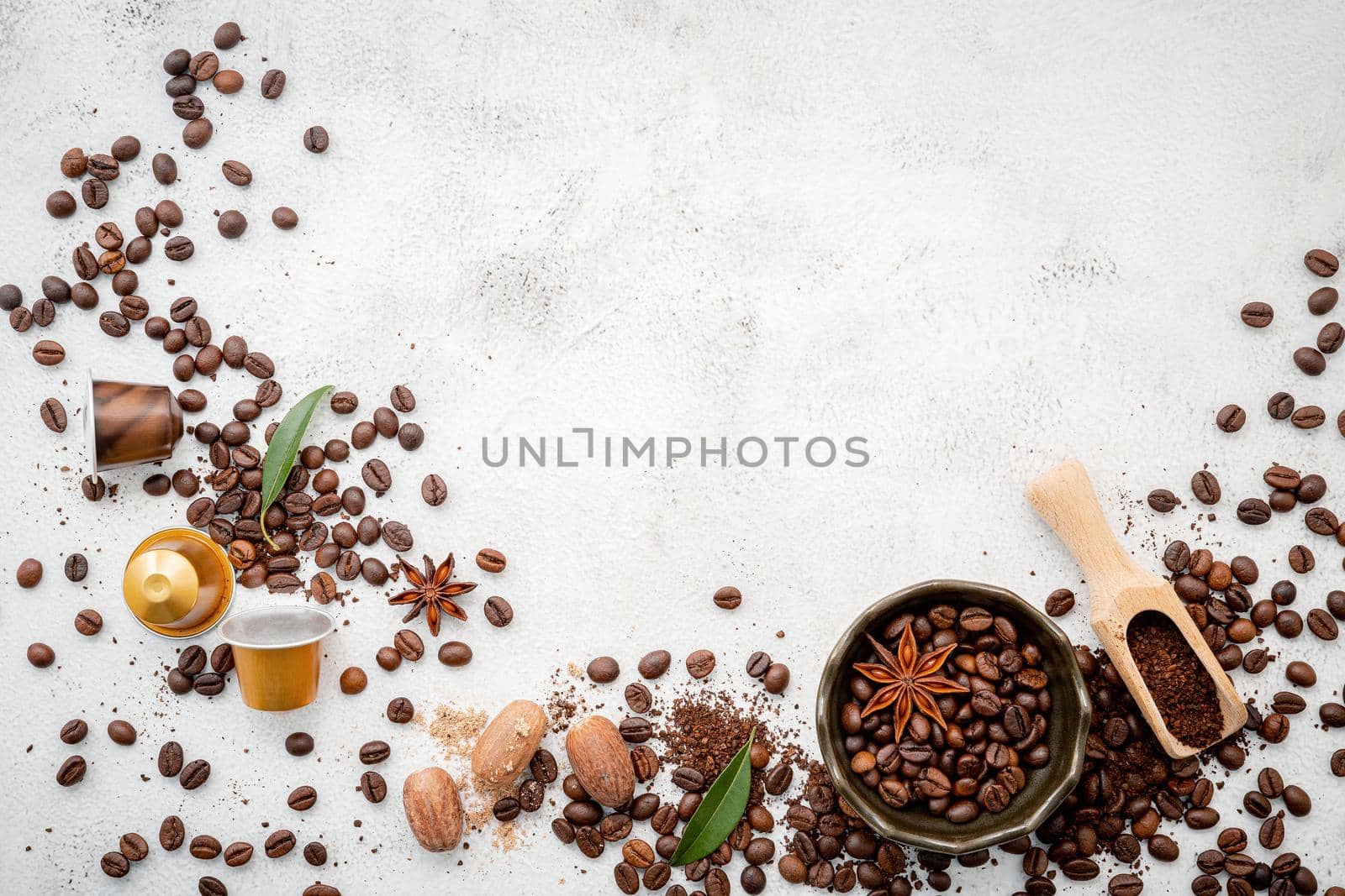 Background of various coffee , dark roasted coffee beans , ground and capsules with scoops setup on white concrete background with copy space.  by kerdkanno