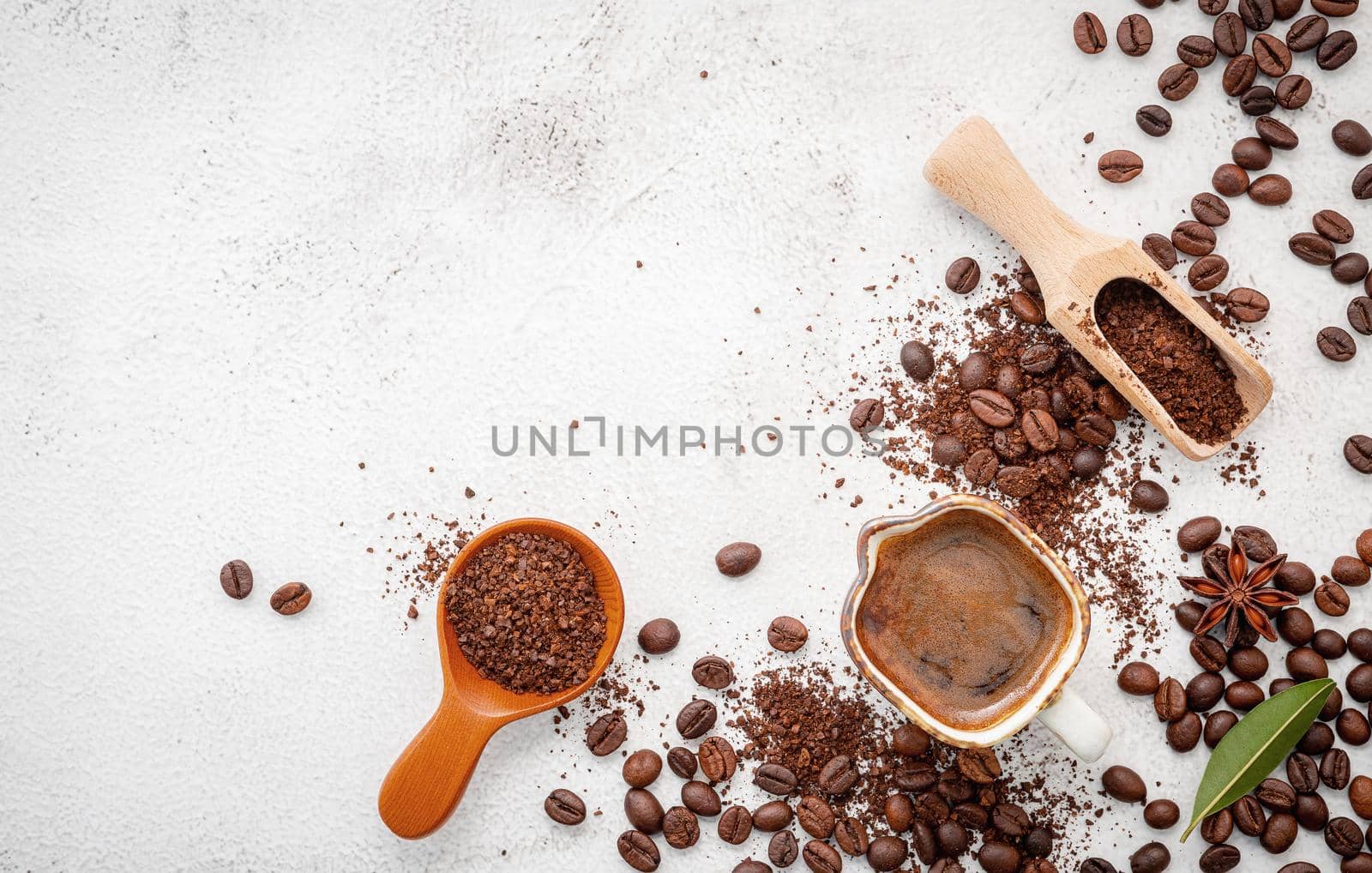 Background of various coffee , dark roasted coffee beans , ground and capsules with scoops setup on white concrete background with copy space.