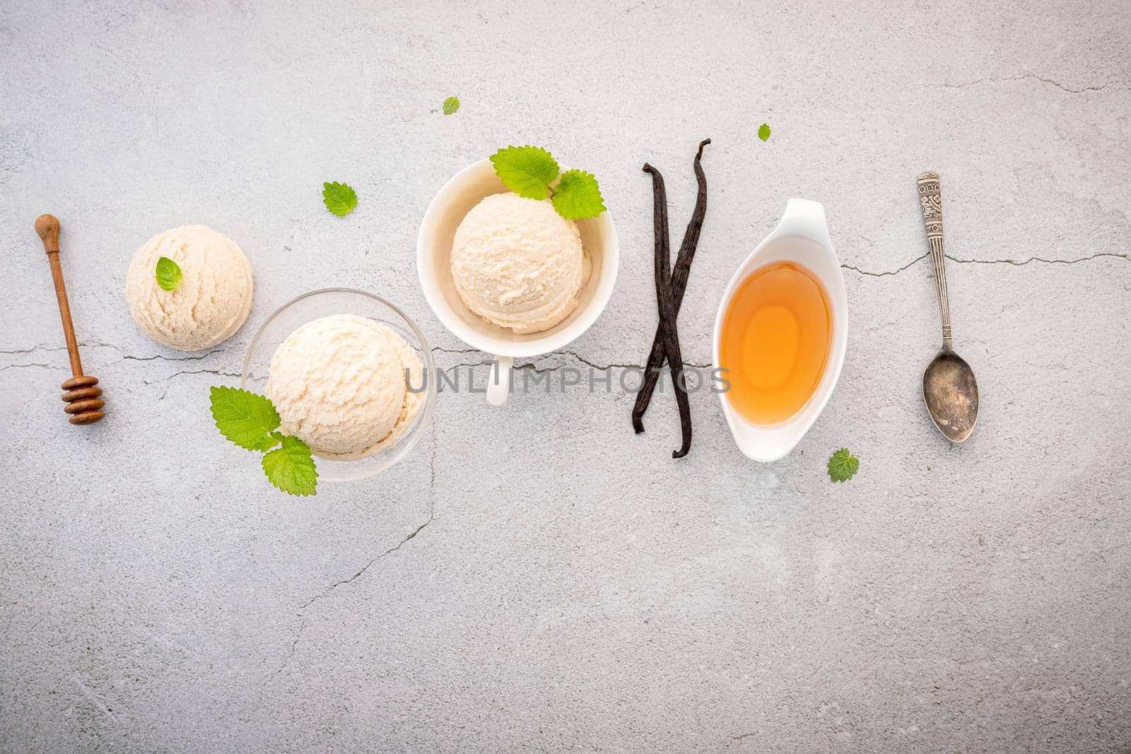 Vanilla ice cream flavor in bowl with vanilla pods setup on concrete background . Summer and Sweet menu concept. by kerdkanno