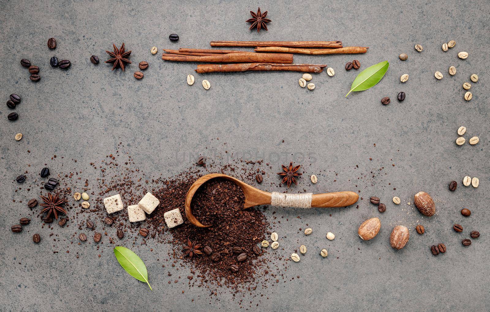 Background of dark roasted coffee beans and coffee powder with scoops setup on dark concrete background with copy space.  by kerdkanno