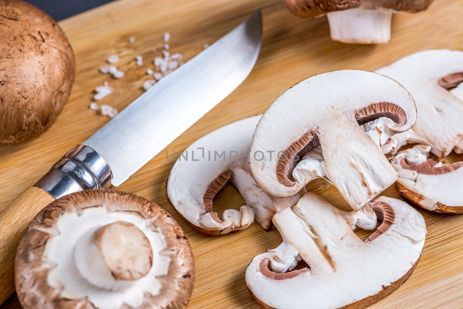 Close-up of a slice of edible mushroom on a cutting board. by galinasharapova