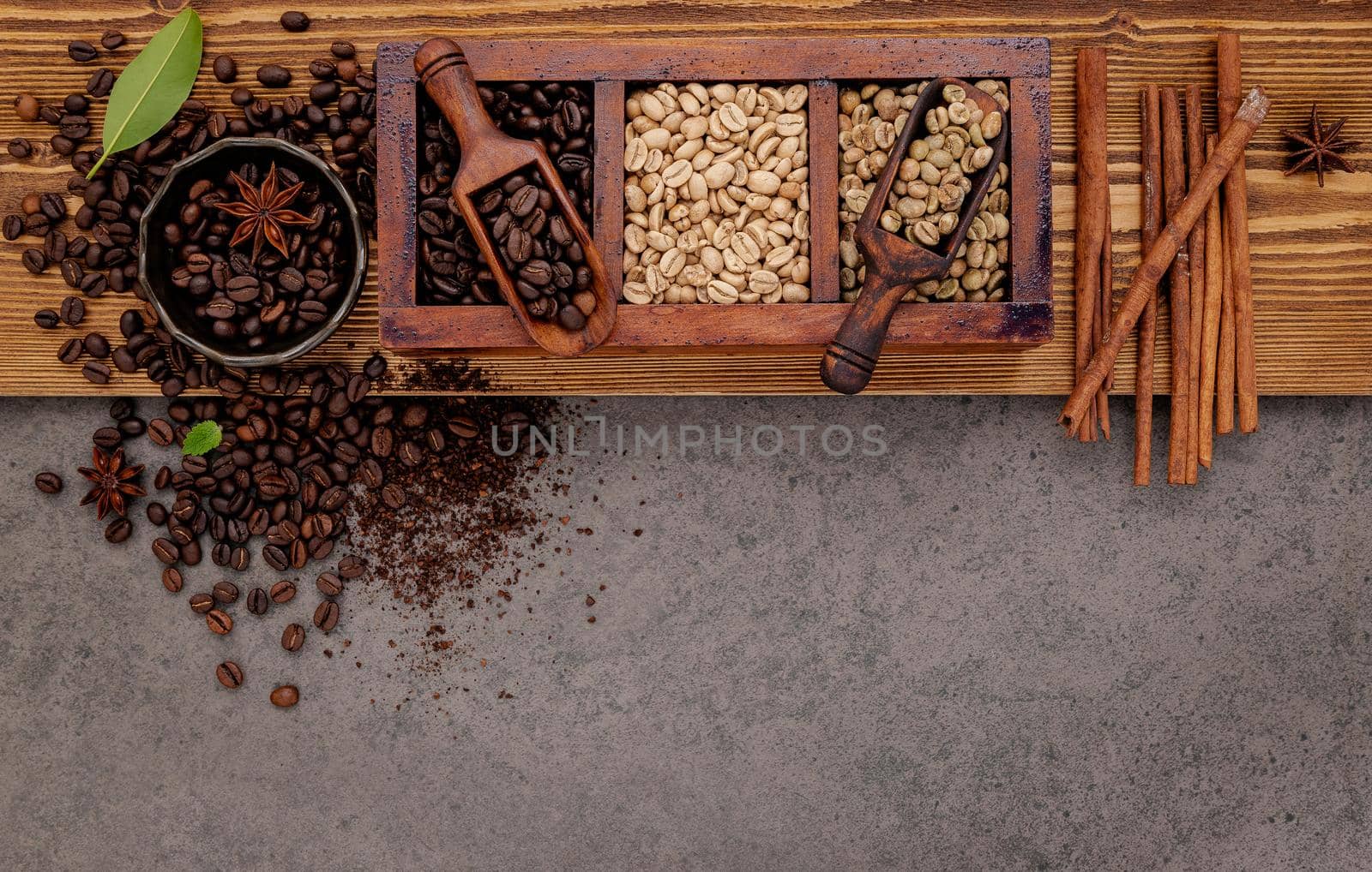 Various of roasted coffee beans in wooden box with manual coffee grinder setup on shabby wooden background. by kerdkanno