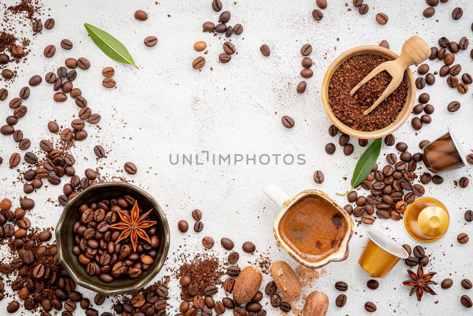 Background of various coffee , dark roasted coffee beans , ground and capsules with scoops setup on white concrete background with copy space.  by kerdkanno