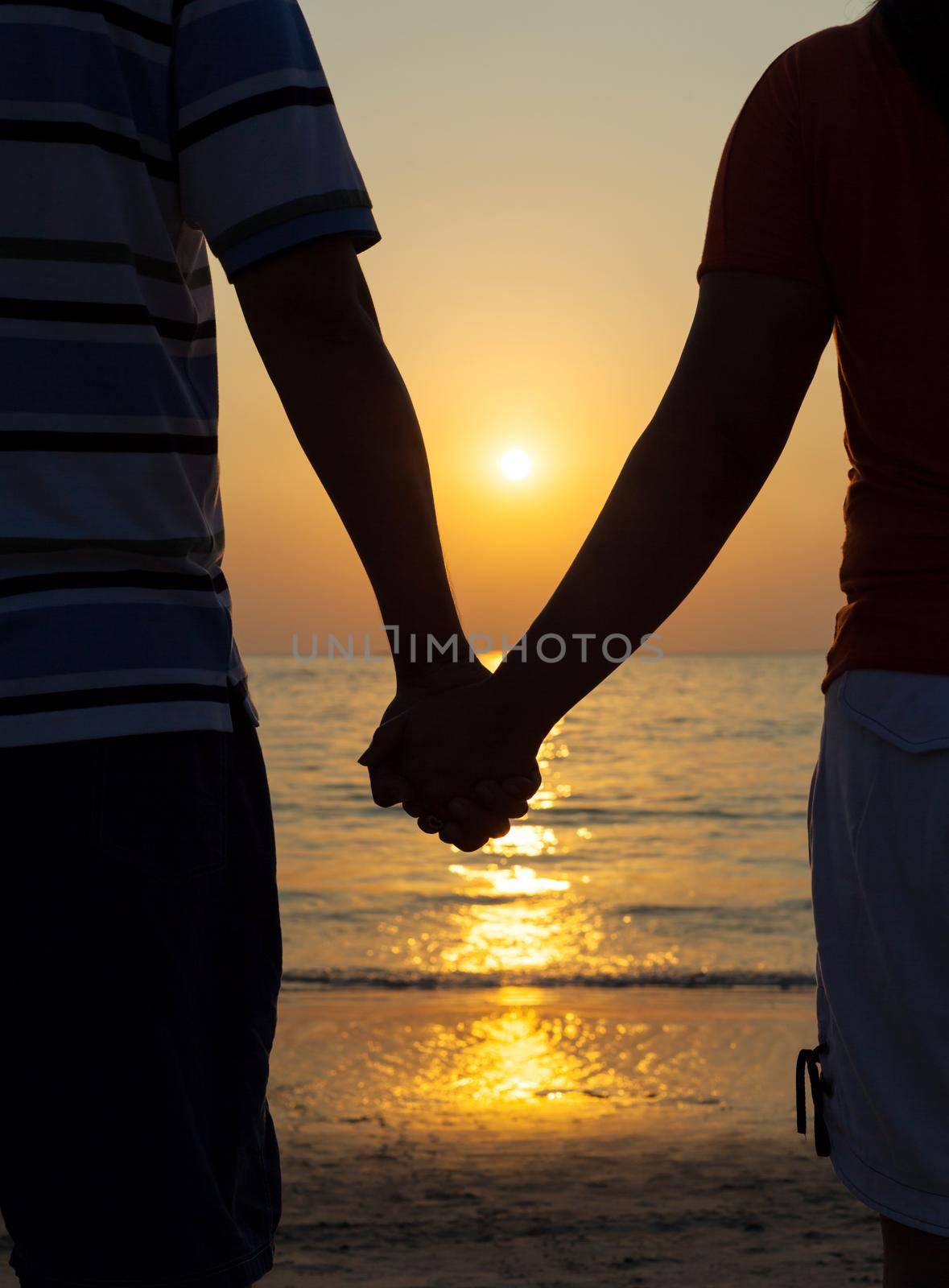 Silhouettes couples holding hands on sunset. by kerdkanno