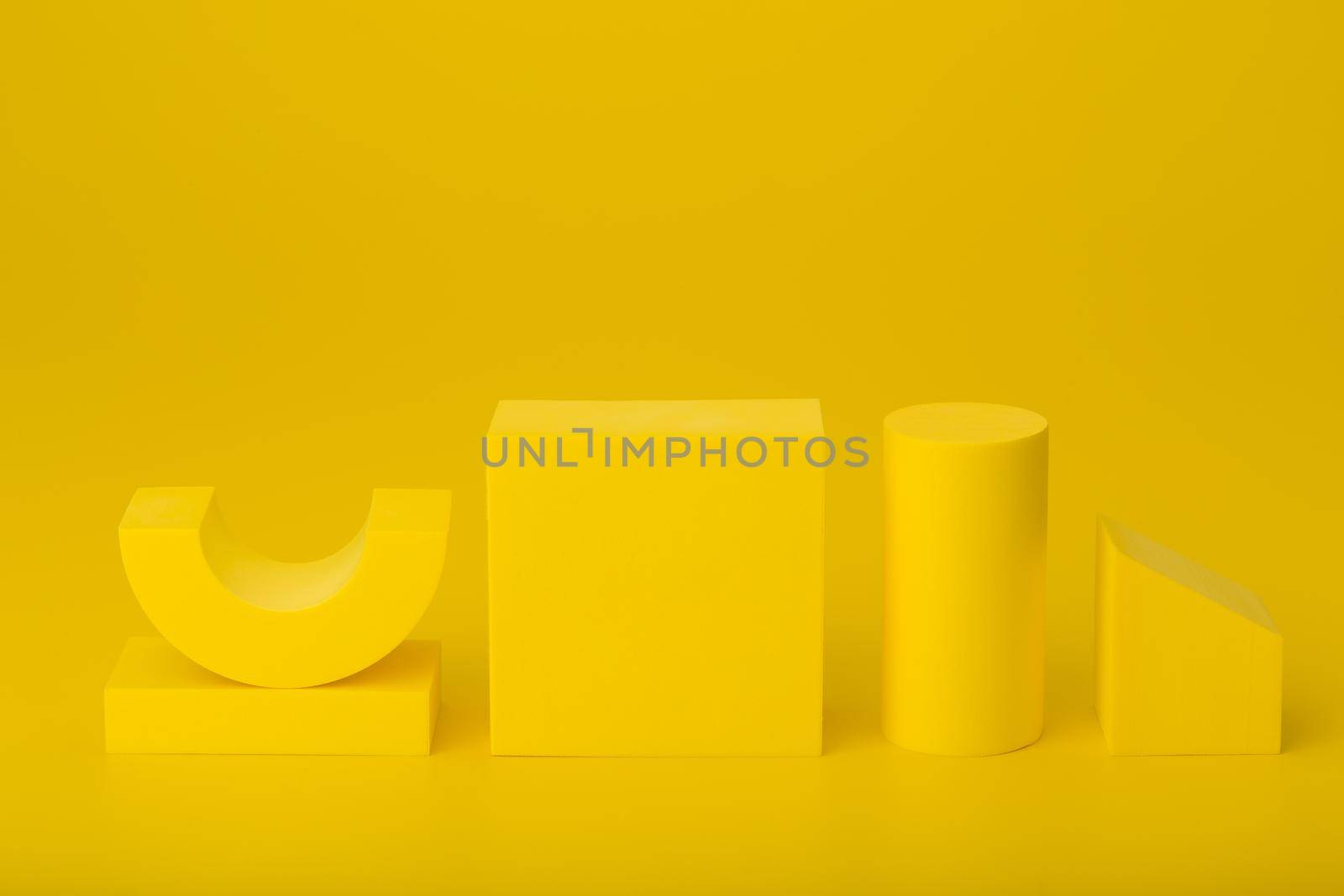Yellow monochromatic abstract background with copy space. Geometric composition with yellow geometric figures against yellow background.