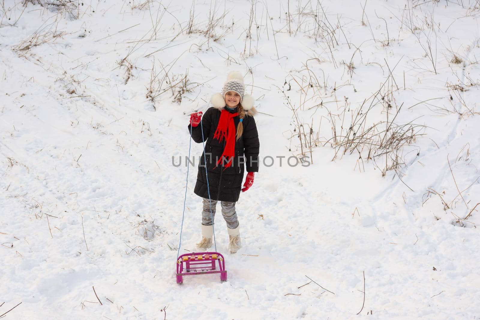 A girl with a sled stands in a snowy meadow by Madhourse