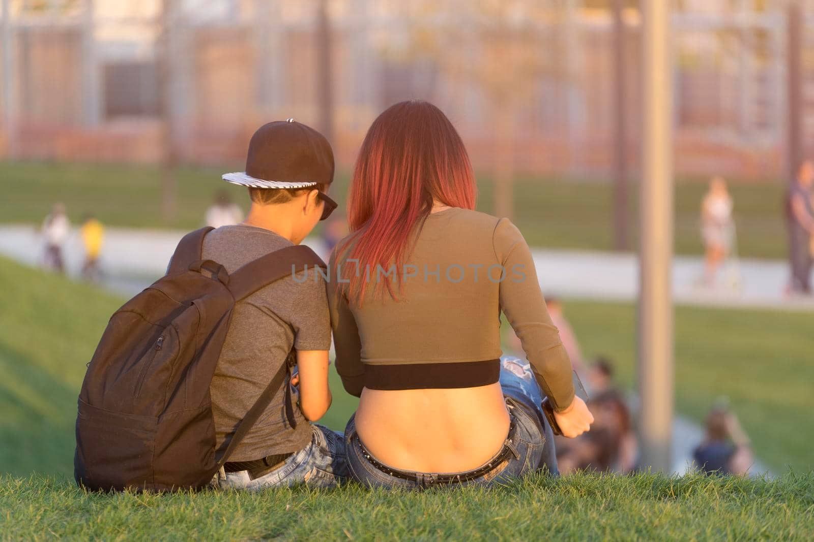 Krasnodar, Krasnodar region-June 8, 2017: young man and girl sitting back on green grass in Galitsky Park.
