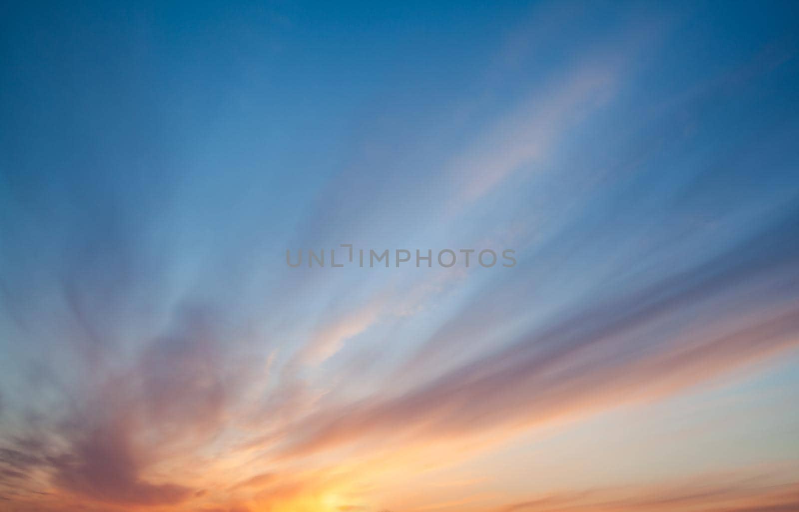 Colorful sunset or sunrise in the sky. The sky and clouds are painted in different delicate colors.