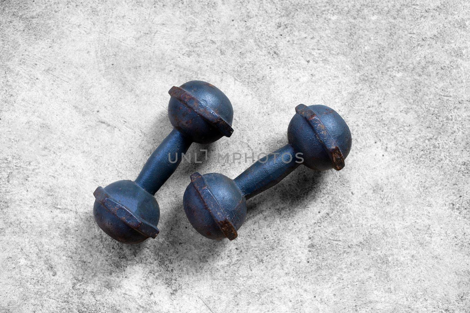Old iron dumbbells on cement floor. Top view