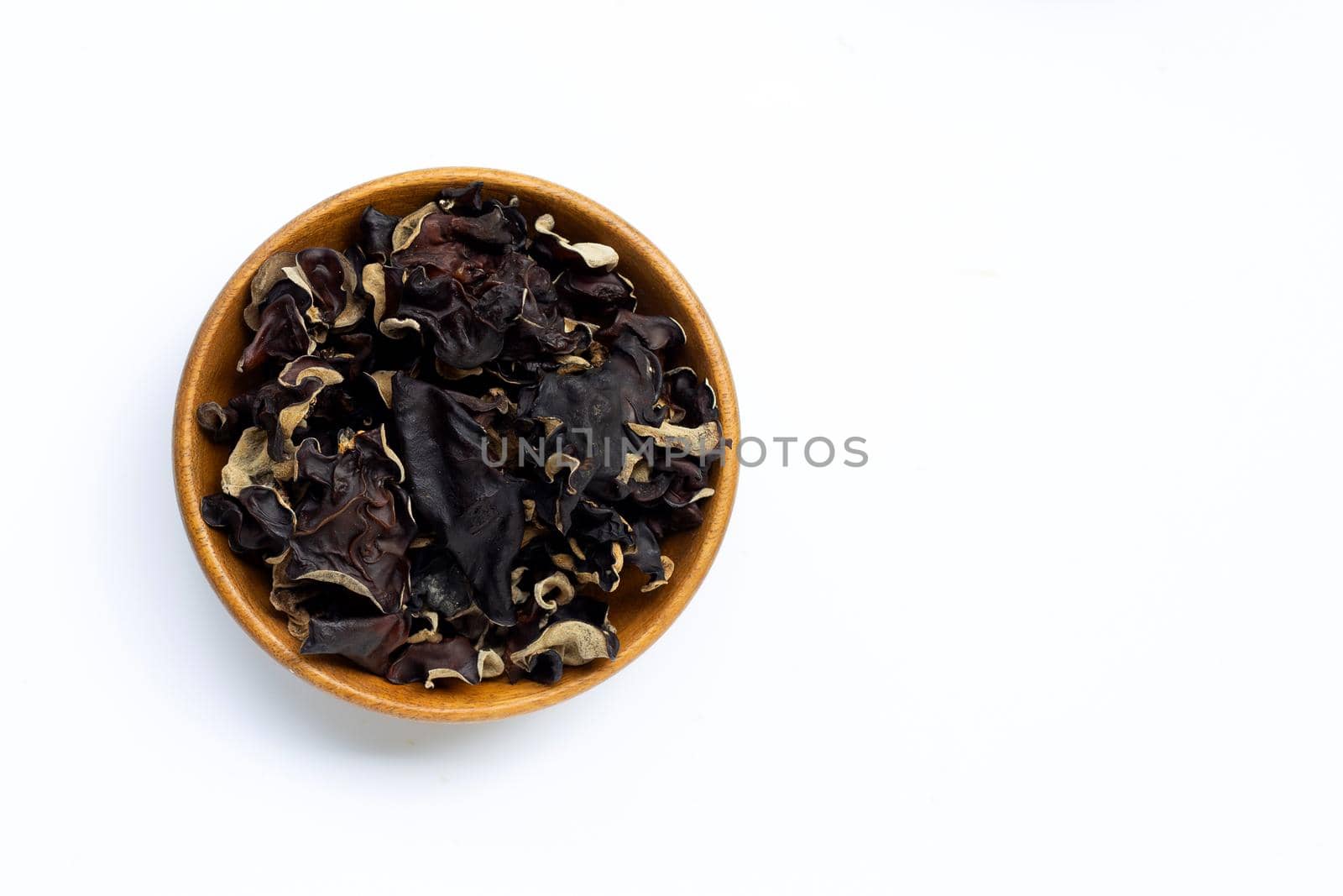 Dried black fungus in wooden bowl on white background.