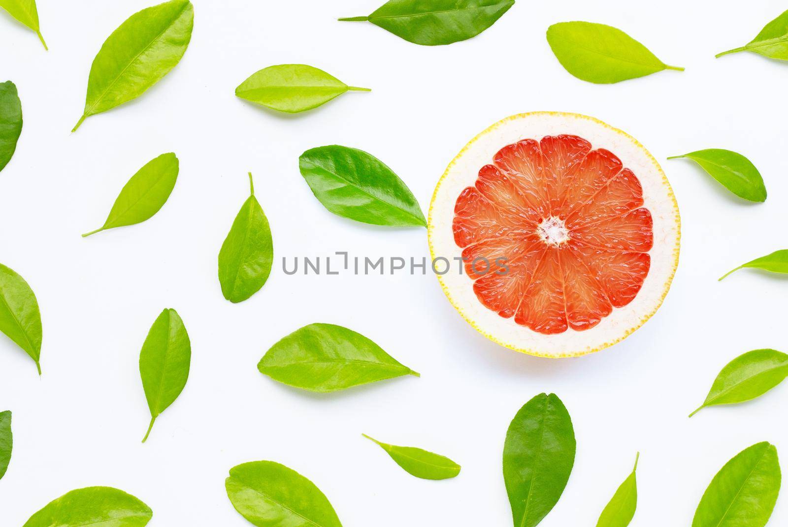 High vitamin C. Juicy grapefruit with leaves on white background. Copy space