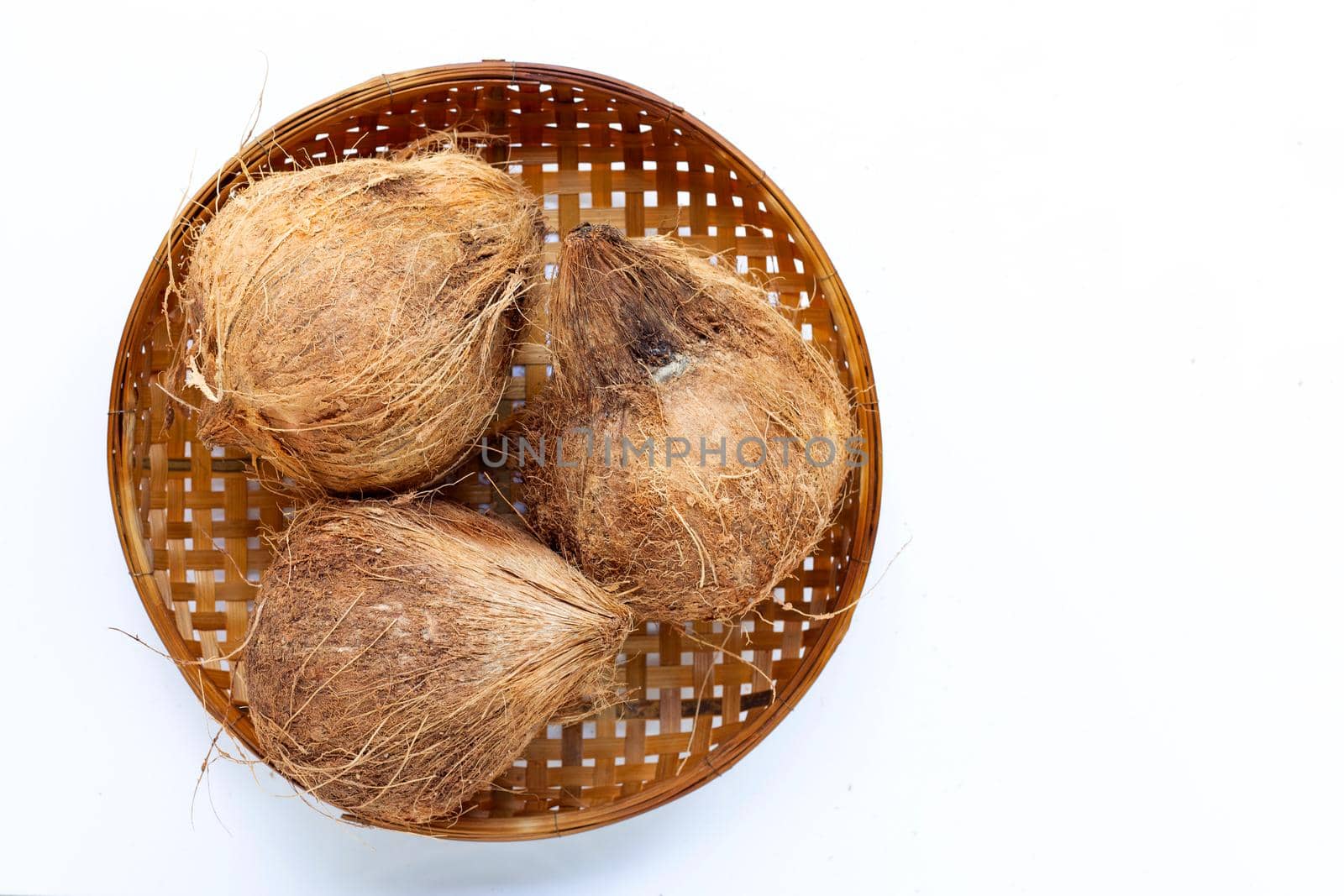Coconut on wooden bamboo threshing basket on white background.