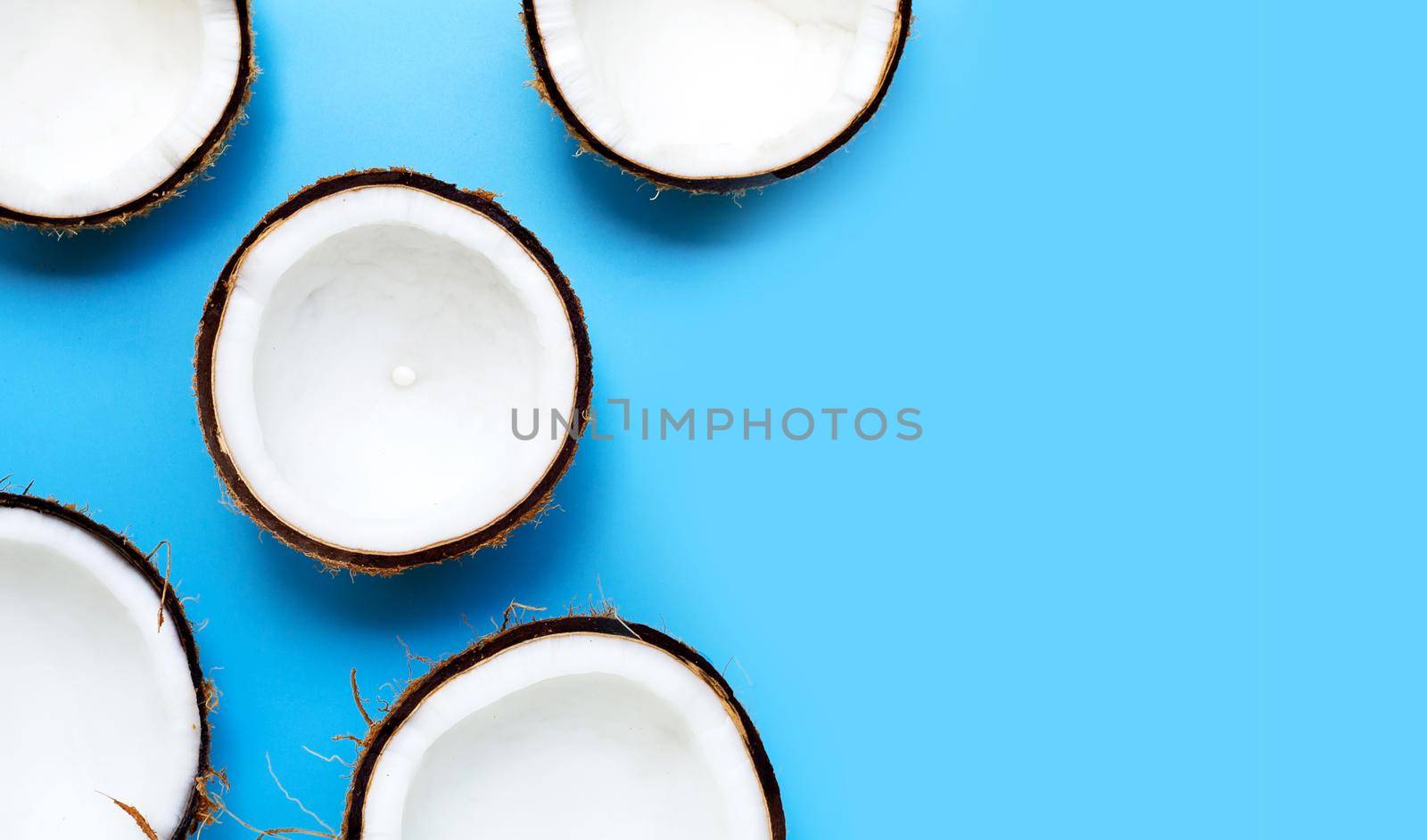 Half coconut on a blue background. Copy space