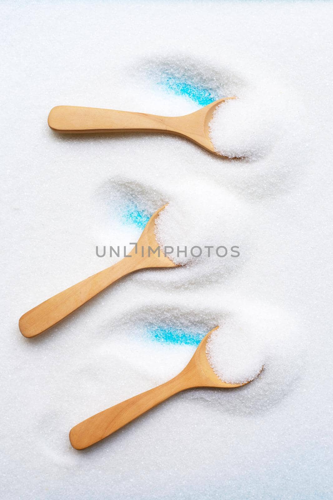 Wooden spoon with white granulated sugar. Top view