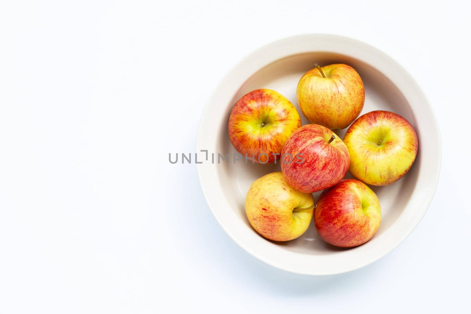 Fresh and juicy apples in bowl on white background. 