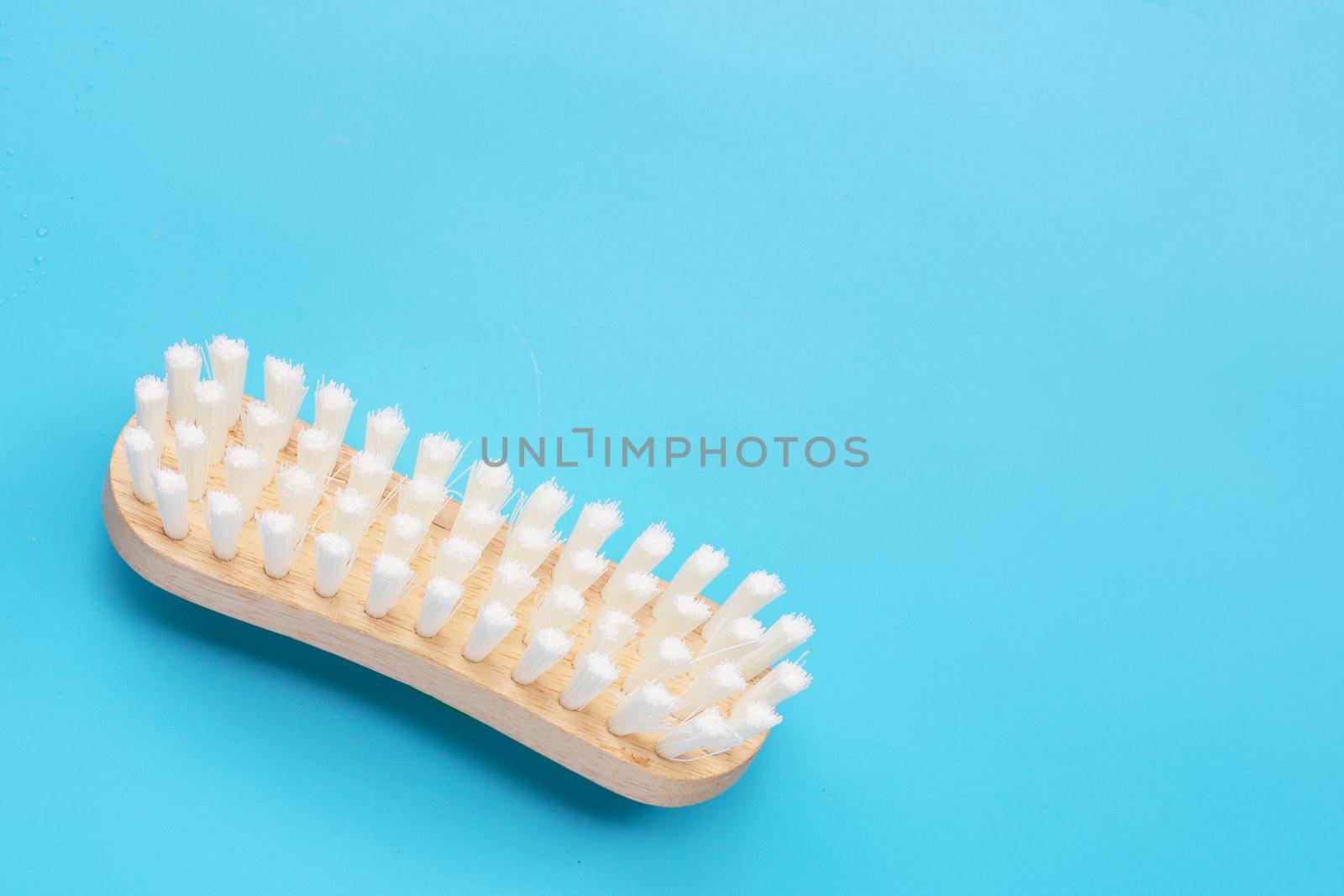 Wooden clothes brush on blue background. Top view