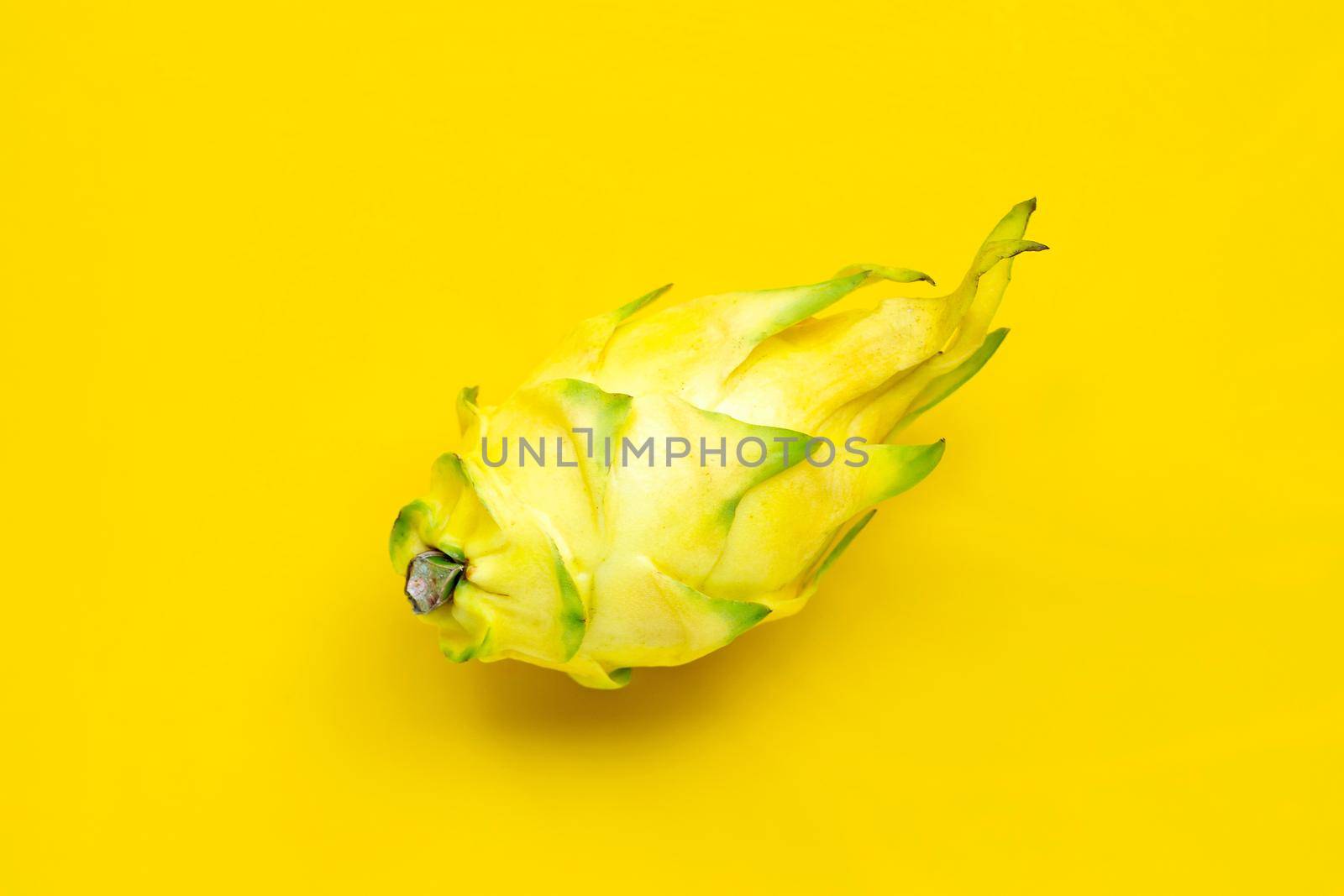 Yellow pitahaya or dragon fruit on yellow background.  Top view