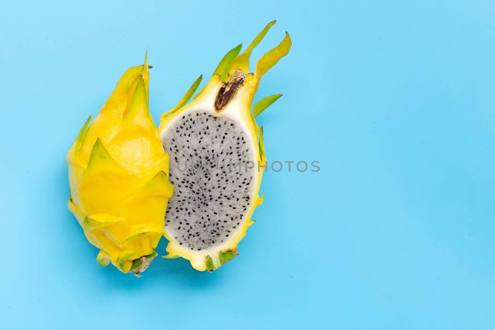 Yellow pitahaya or dragon fruit on blue background. Copy space