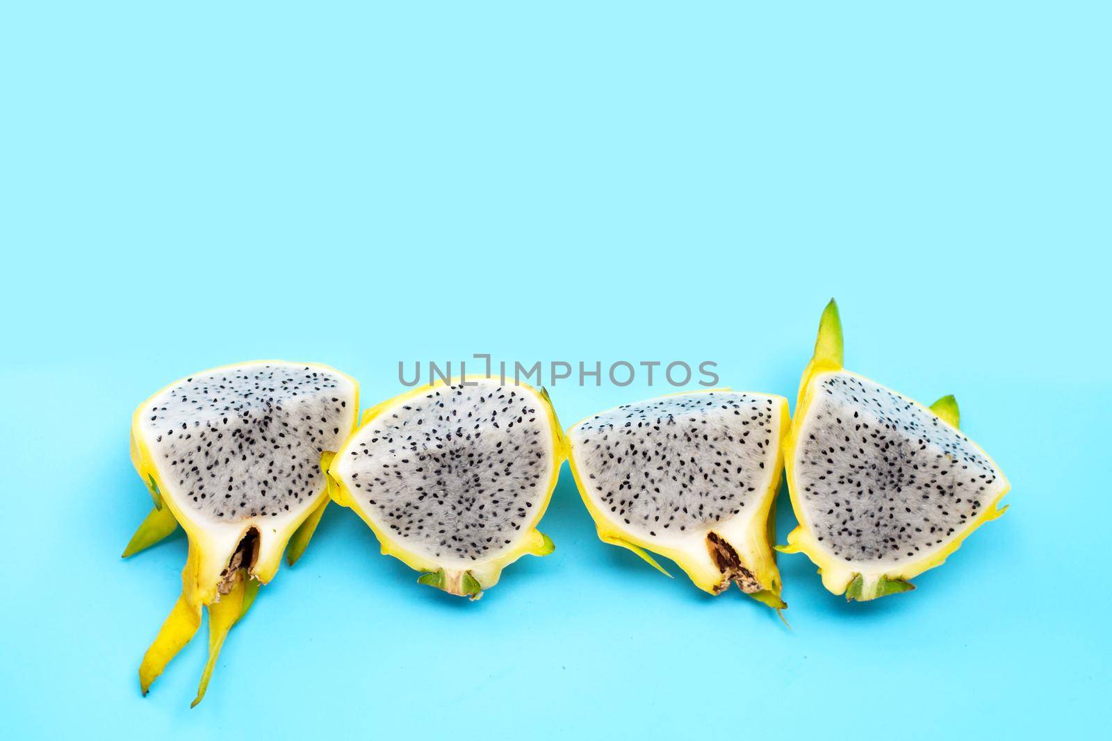 Yellow pitahaya or dragon fruit on blue background.  Top view