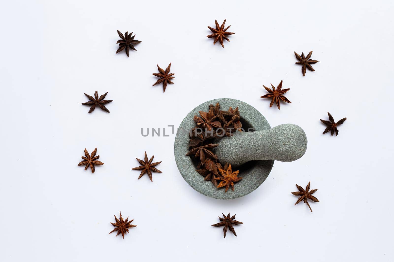 Star anis in  stone mortar with pestle on white background. Top view