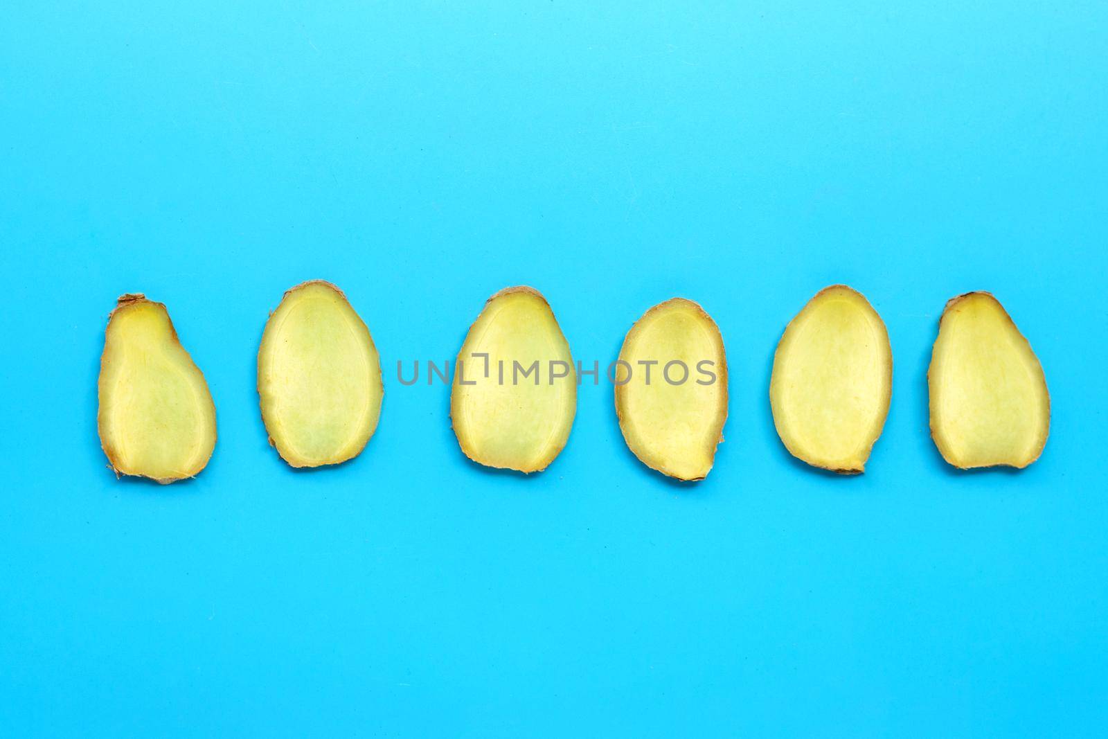 Ginger slices on blue background.  Top view