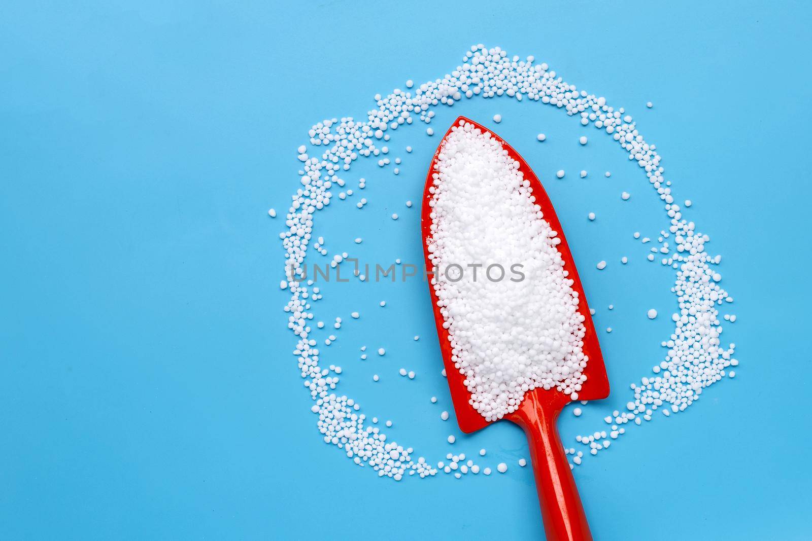 Chemical plant urea fertilizer on blue background. Copy space