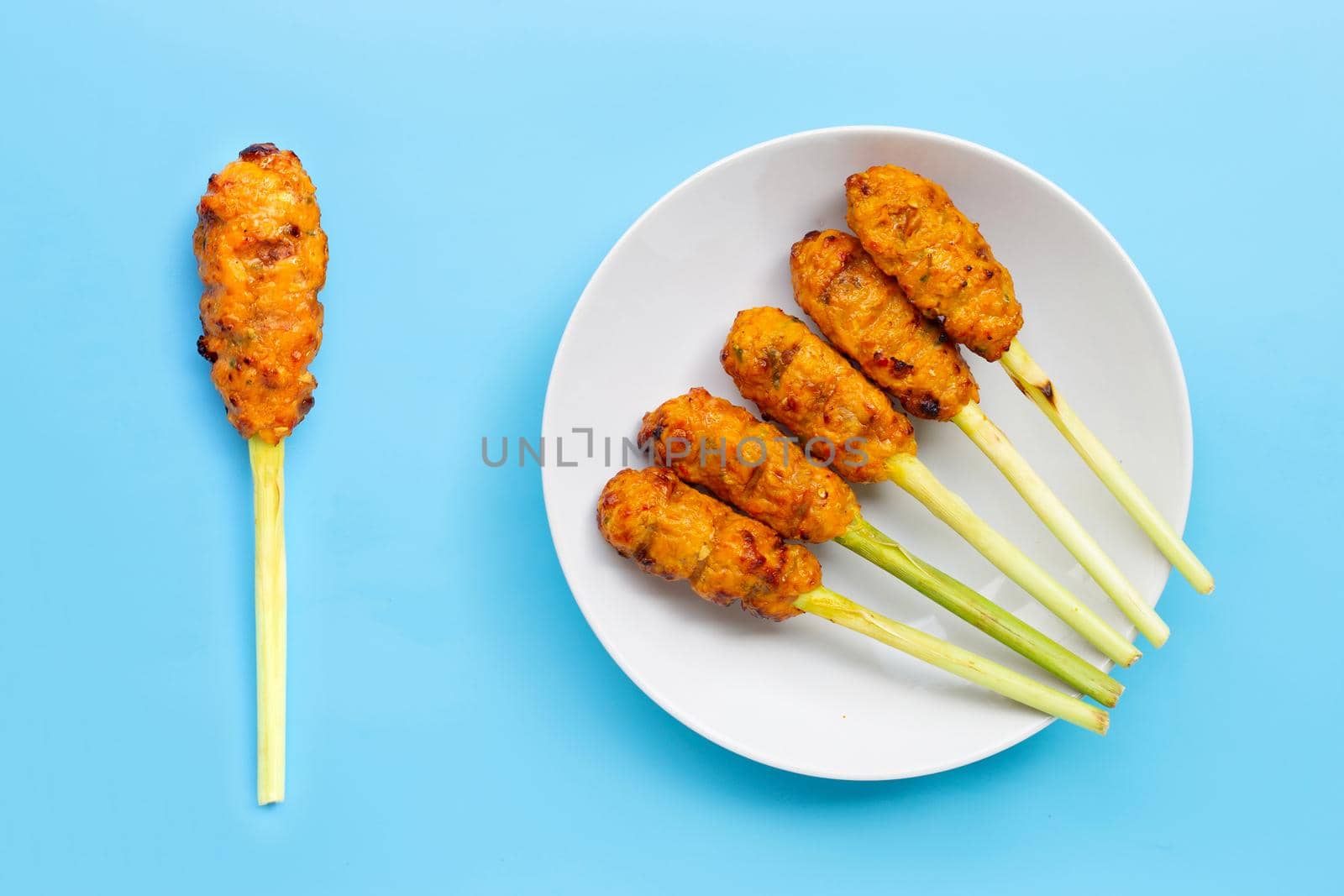 Grilled minced chicken with curry paste and coconut cream on lemongrass skewers. Top view