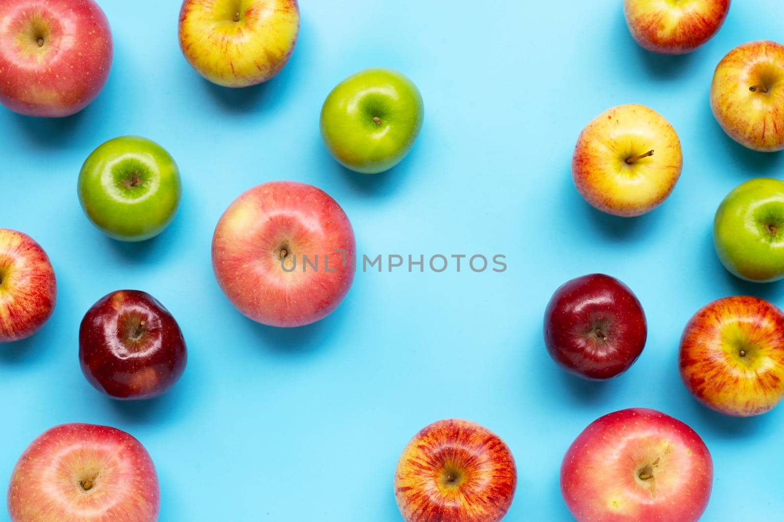 Ripe apples on blue background. Top view