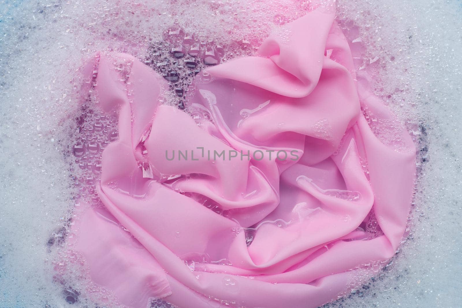 Color clothes soak in powder detergent water dissolution. Laundry concept