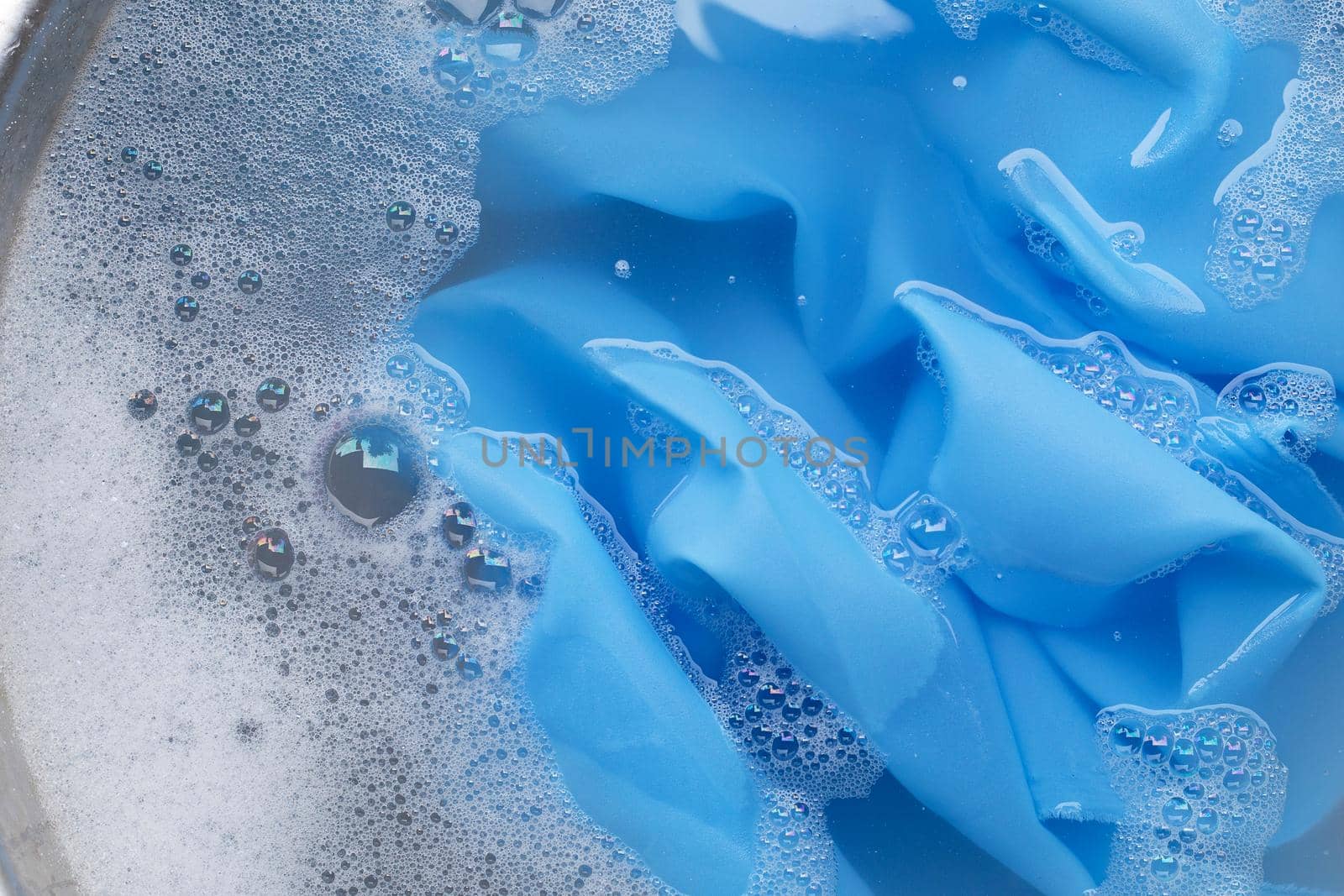 Blue clothes soak in powder detergent water dissolution. Laundry concept