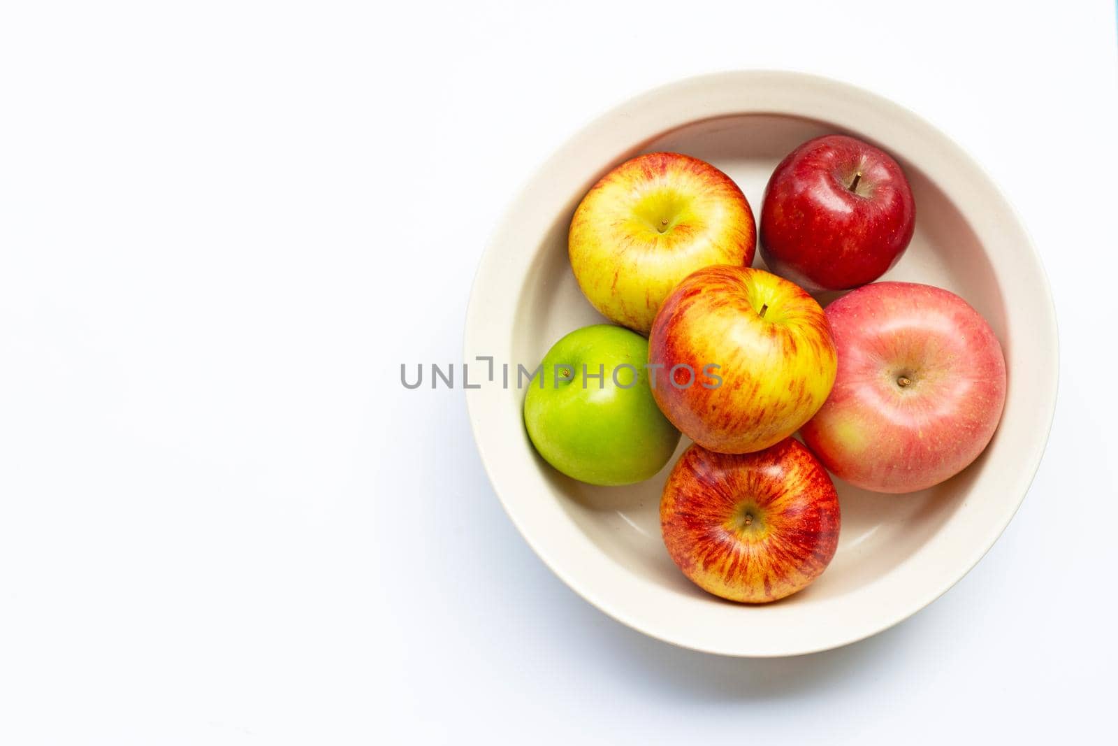 Ripe apples in bowl on white background. Top view