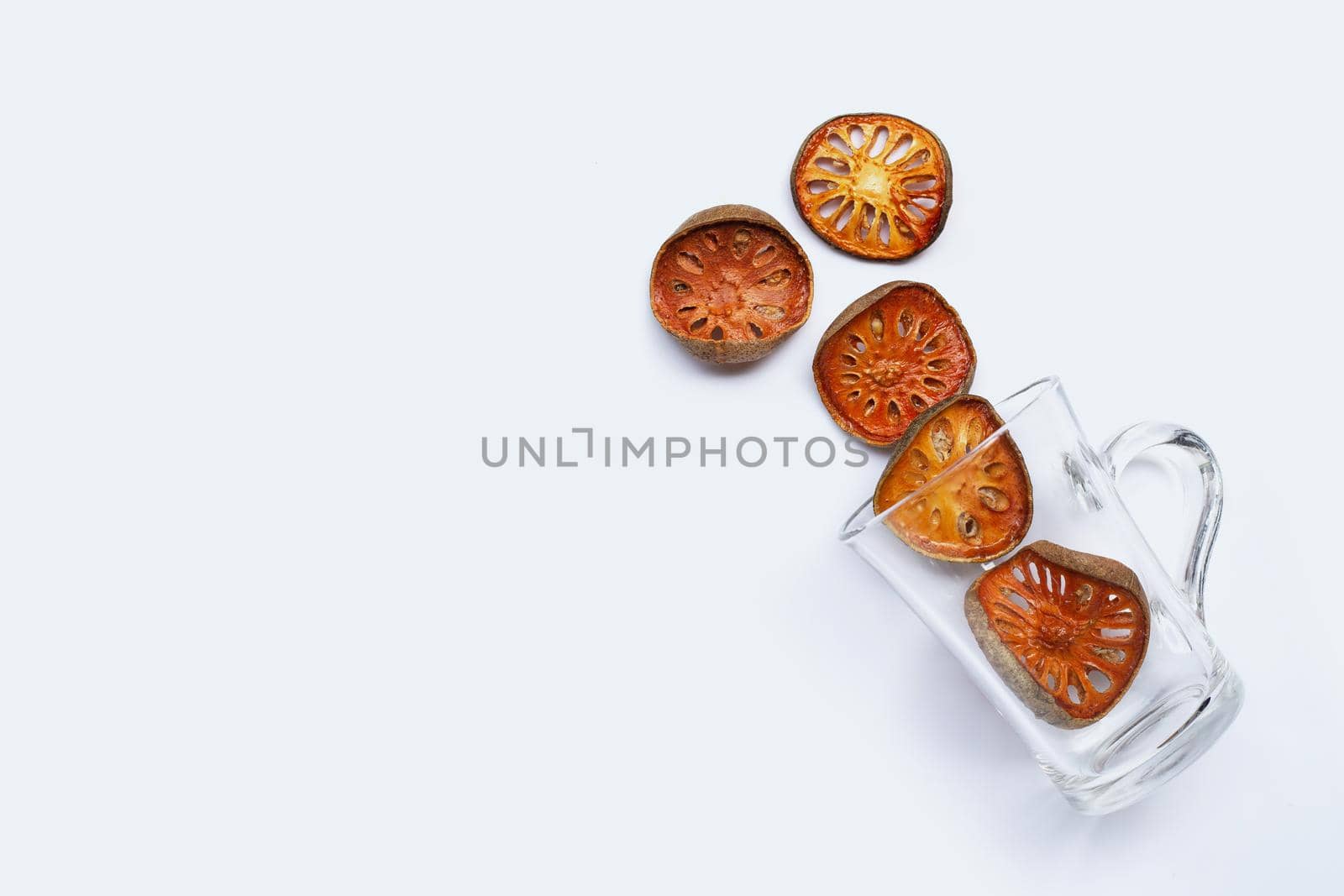Dried bael fruit with glass on white background. Top view