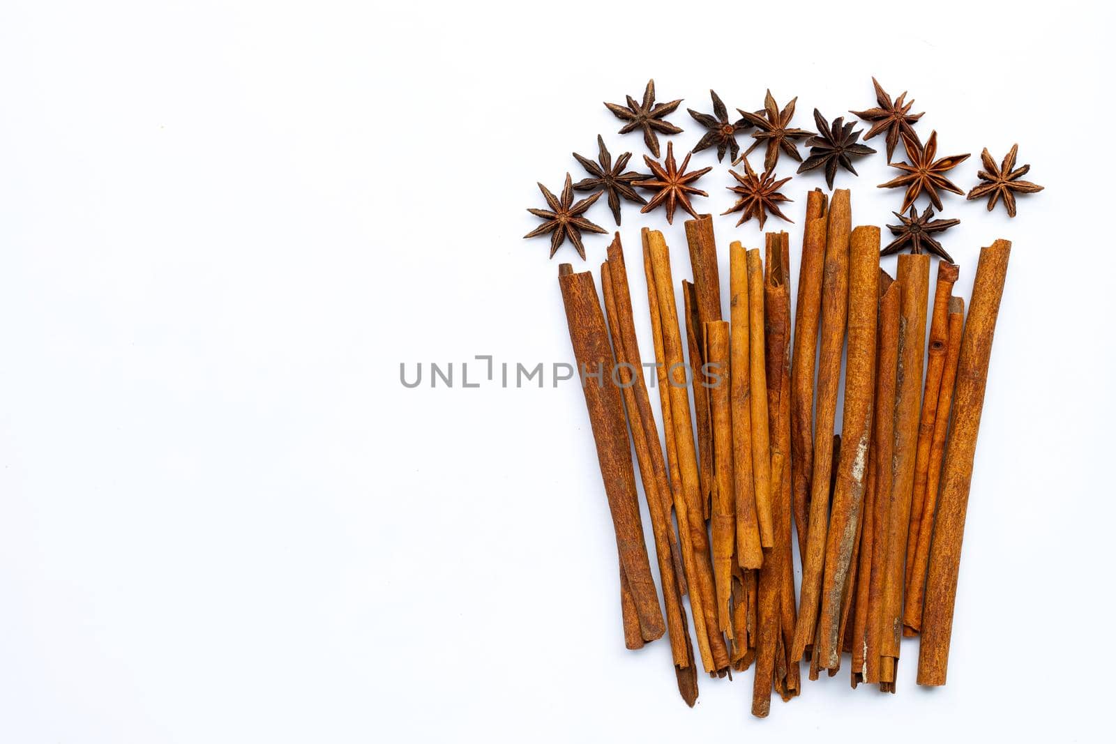 Star anis and cinnamon sticks on white background.
