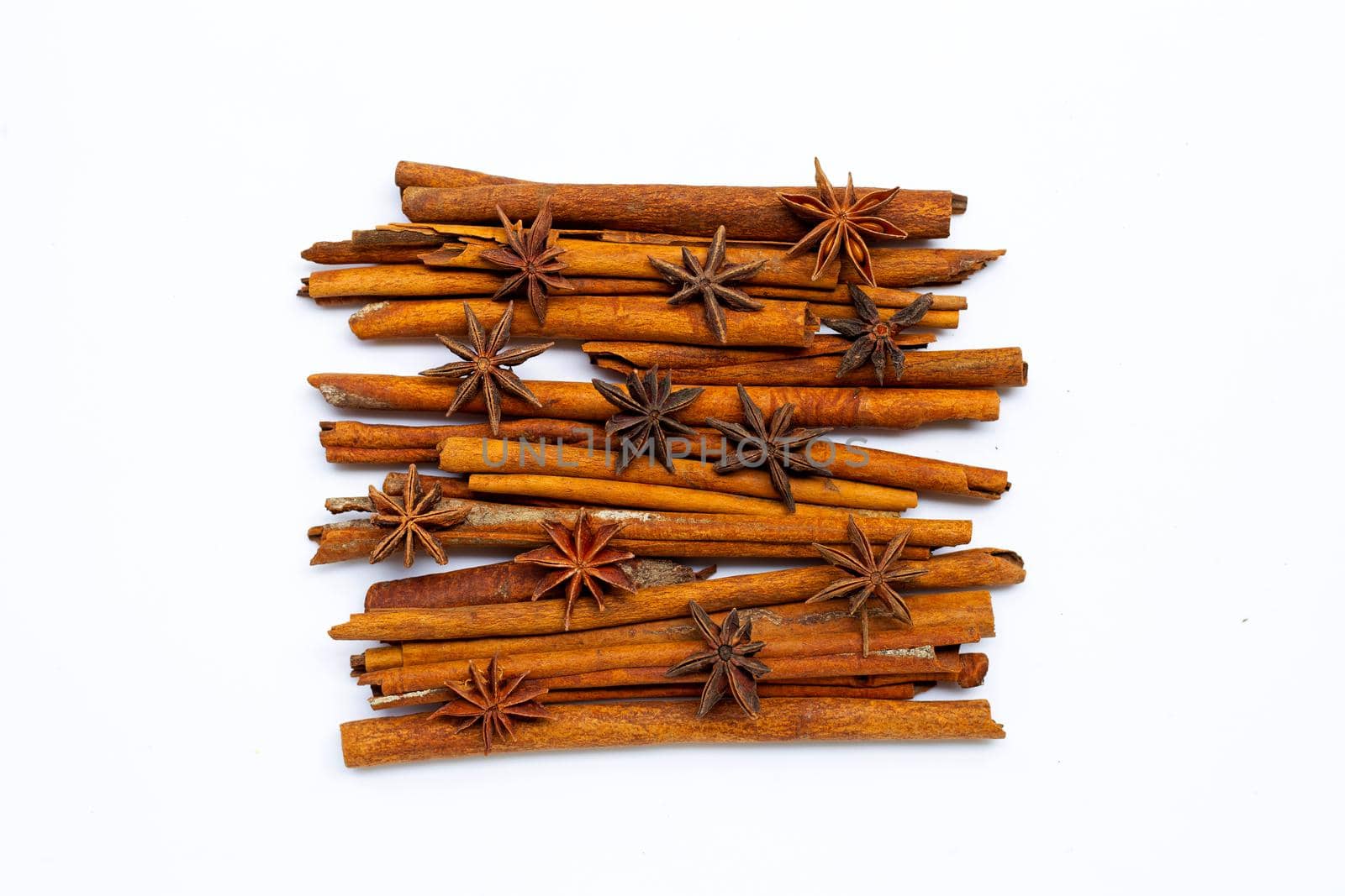 Star anis and cinnamon sticks on white background.
