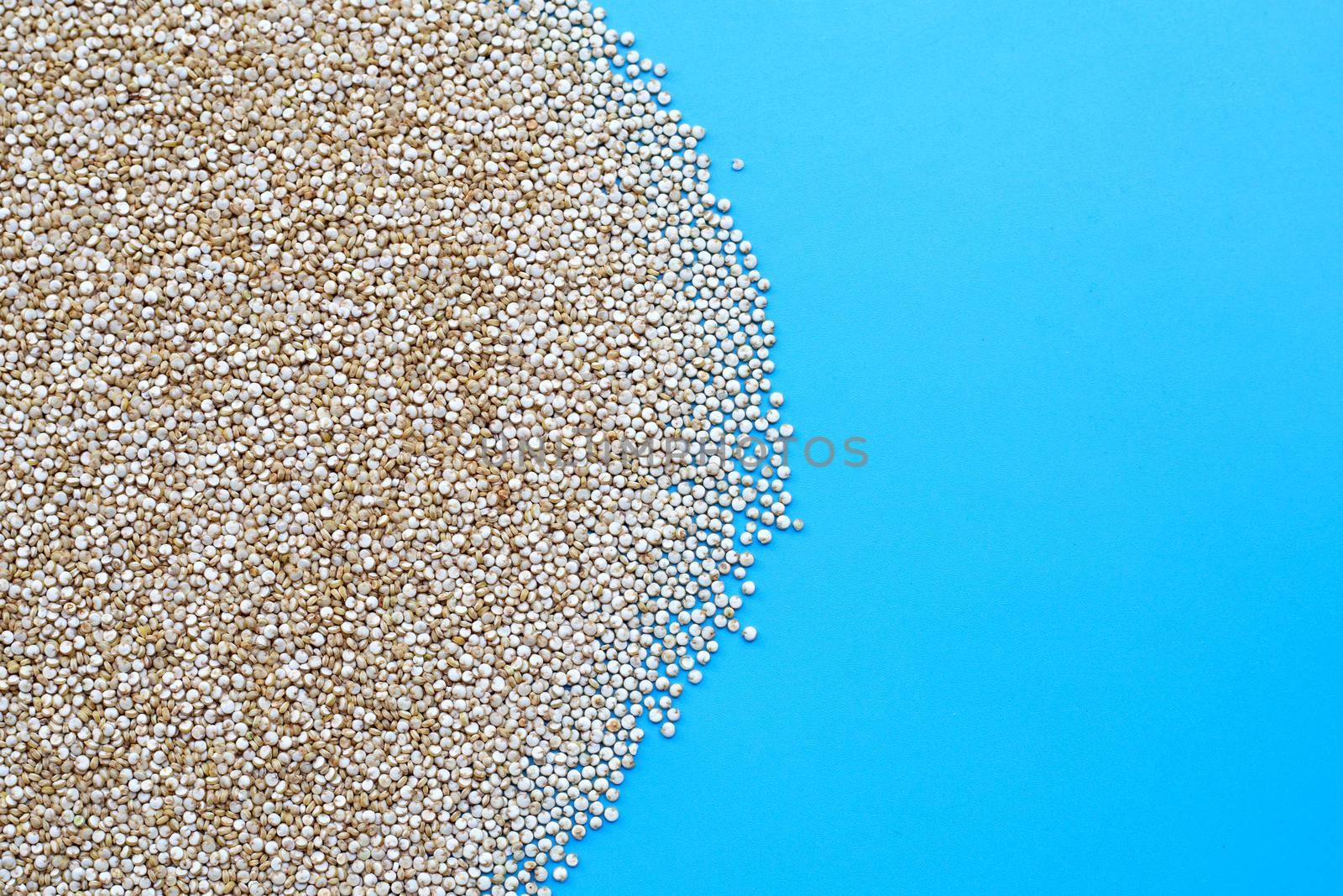 Organic Quinoa on blue background. Copy space
