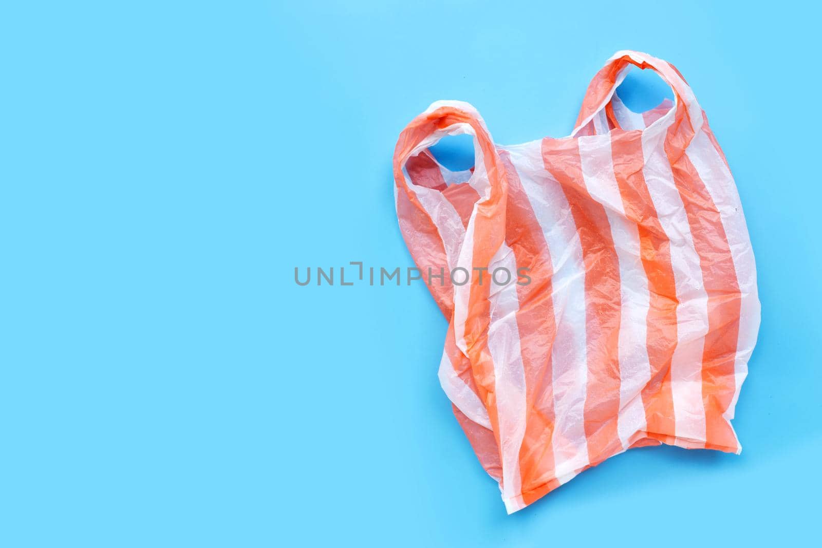 Colorful plastic bags on blue background.  Copy space