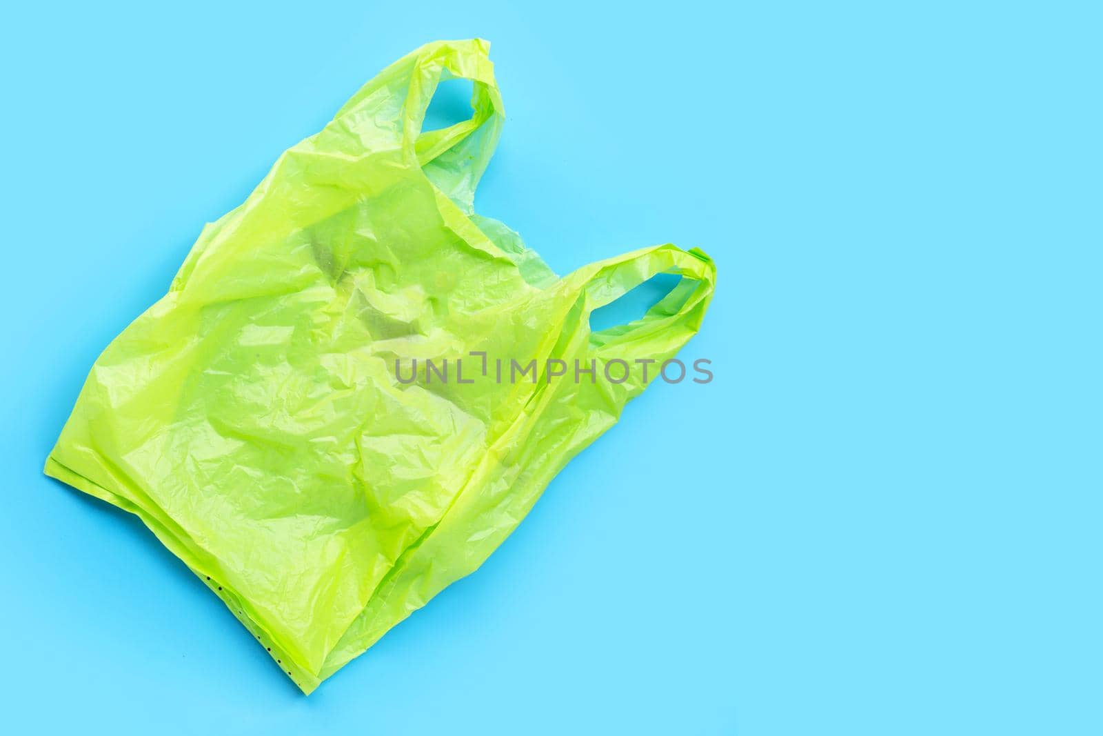Colorful plastic bags on blue background. Copy space