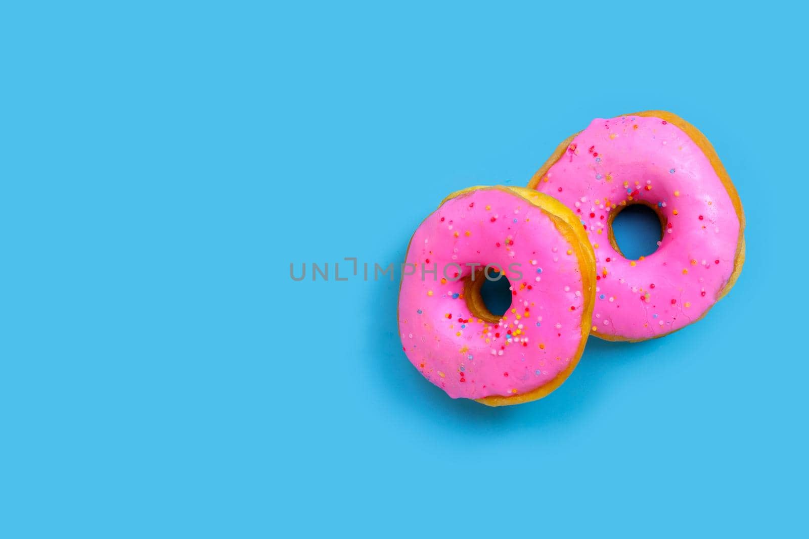 Pink donuts on blue background. Top view