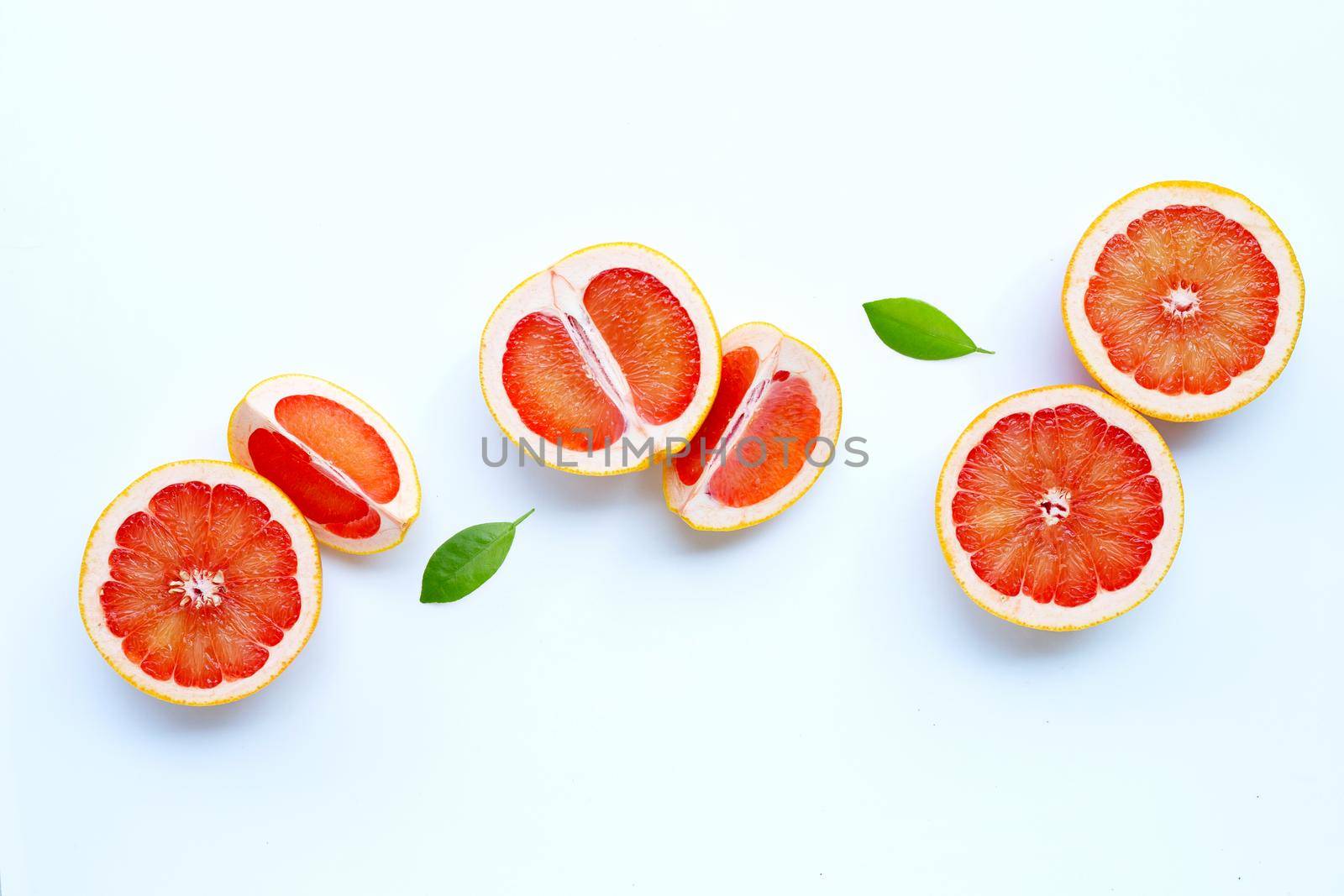 High vitamin C. Juicy grapefruit with leaves on white background.