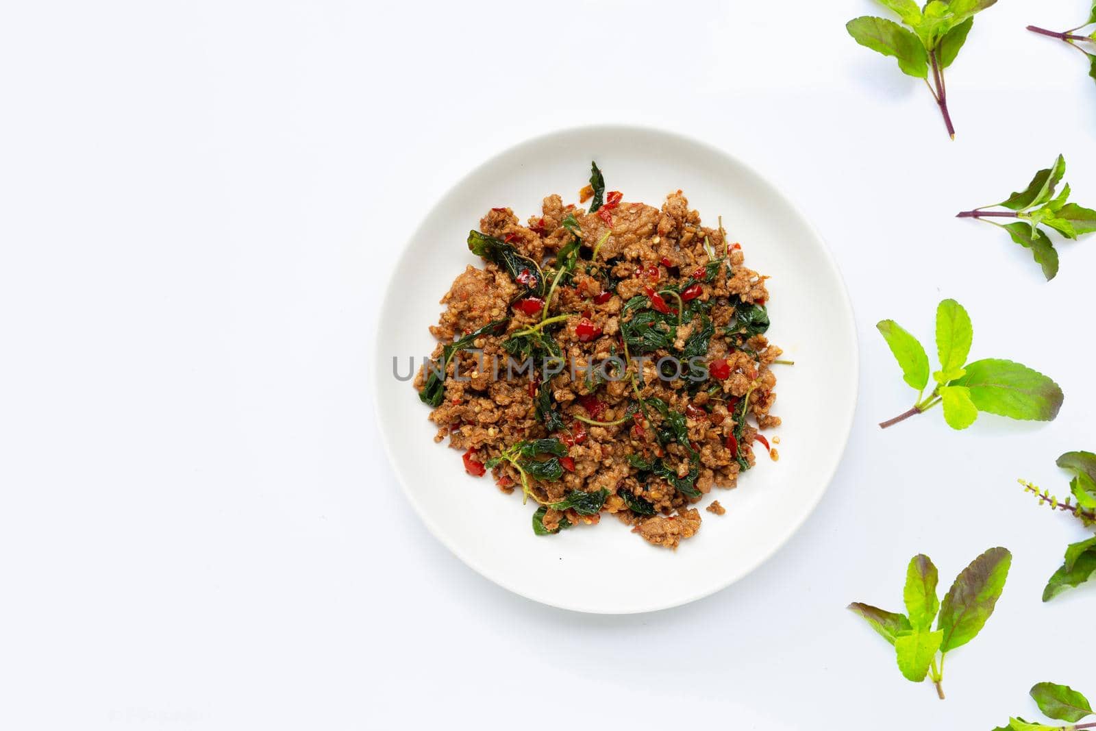 Thai food. Stir-fried minced pork with basil leaves on white background.