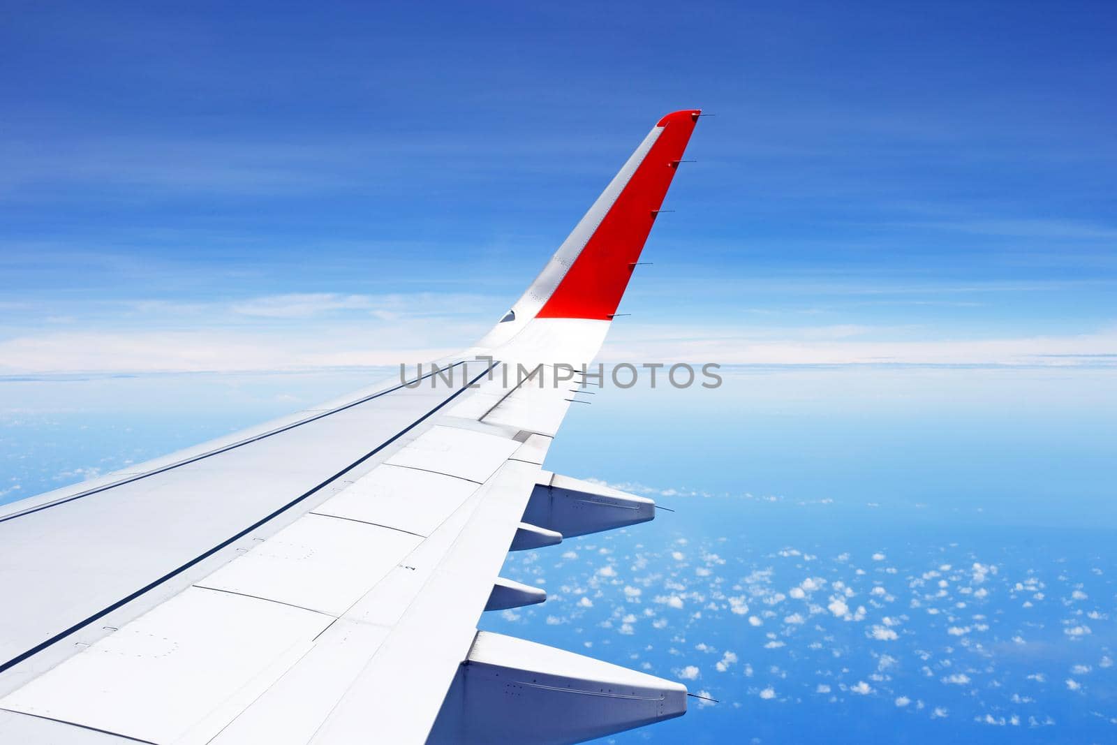 View of sky cloud and wing of airplane from window