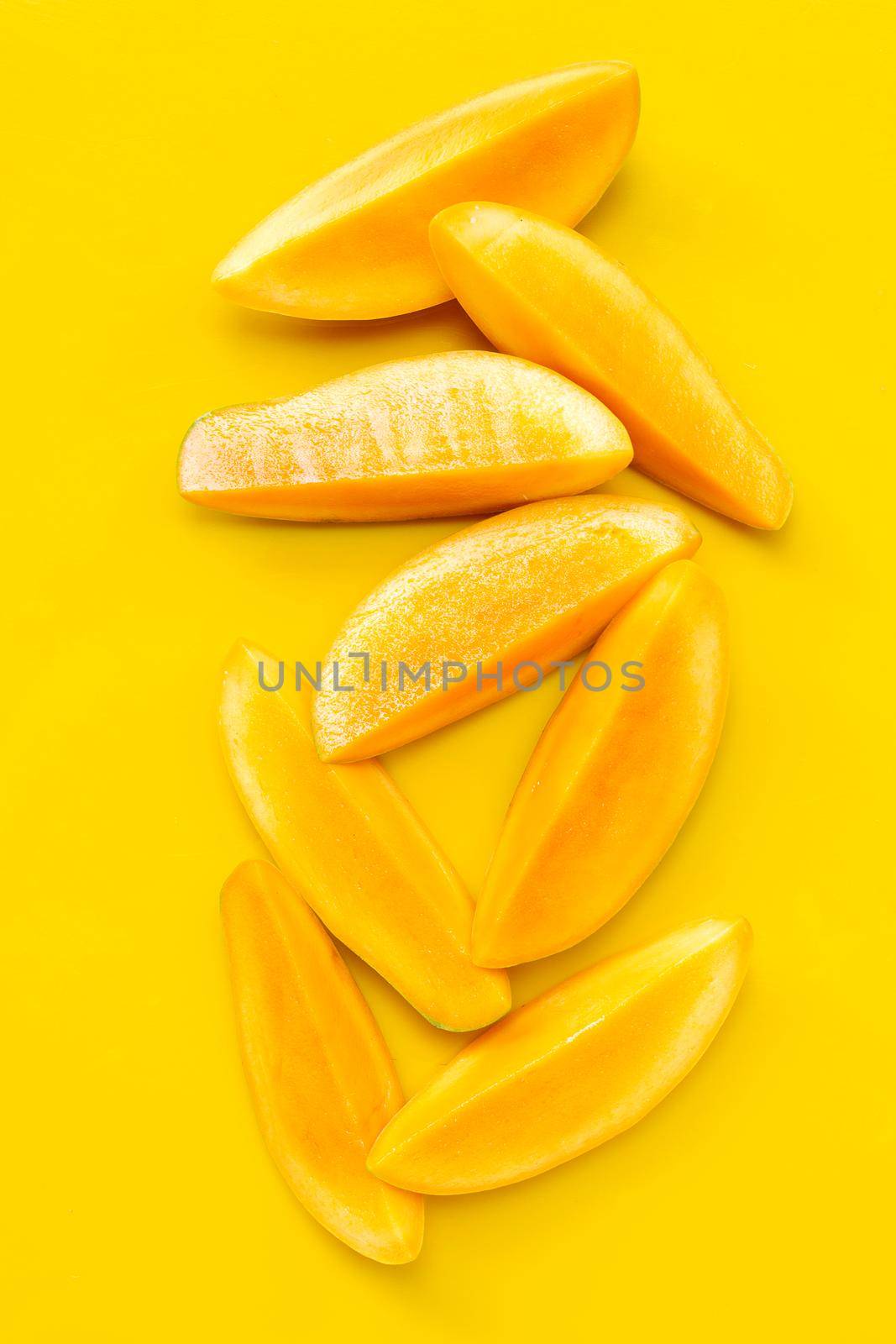 Tropical fruit, Mango  slices on yellow background. Top view